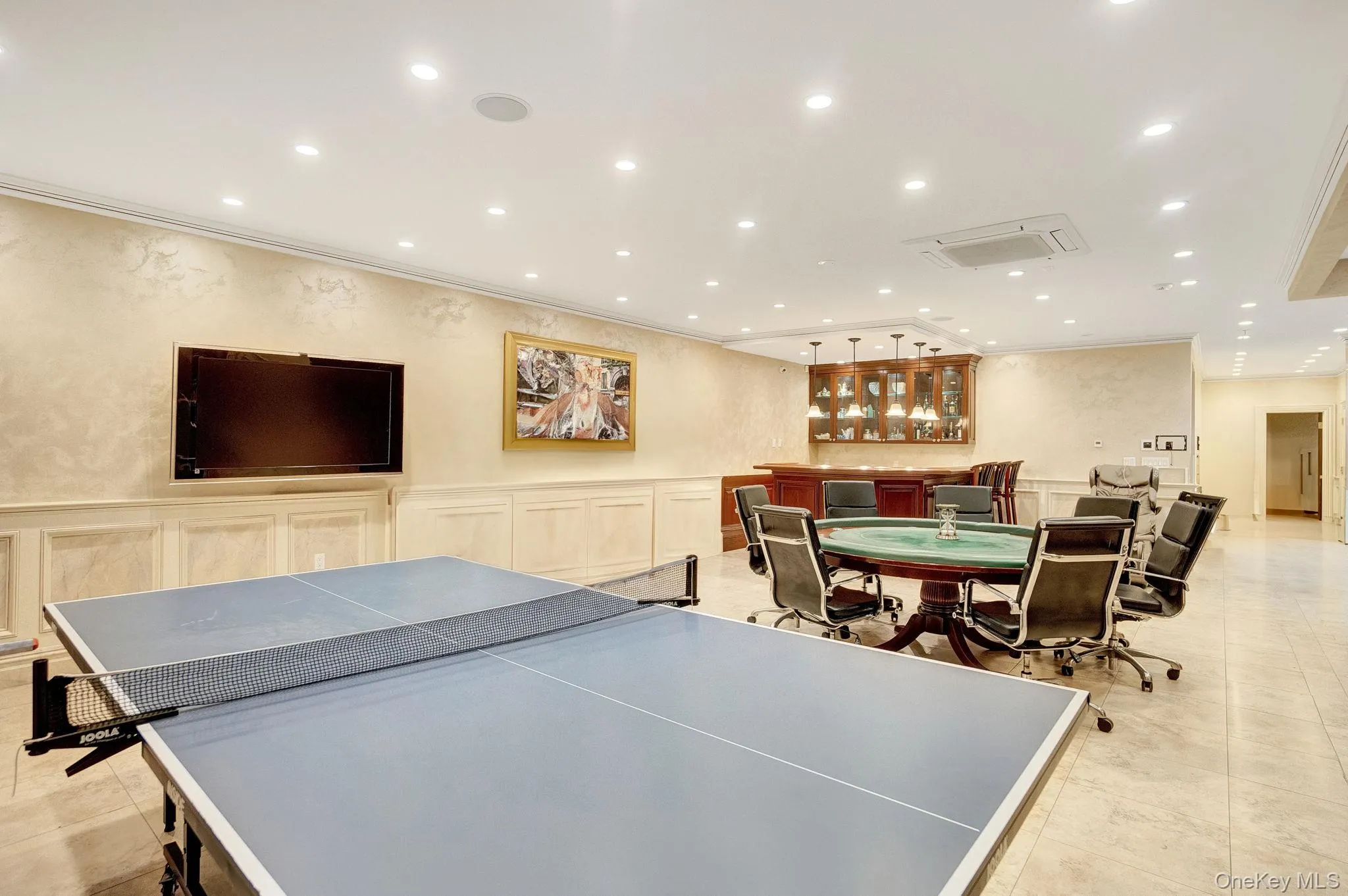 Rec room featuring recessed lighting, a wainscoted wall, ornamental molding, and a decorative wall Rec room featuring recessed lighting, a wainscoted wall, ornamental molding, and a decorative wall