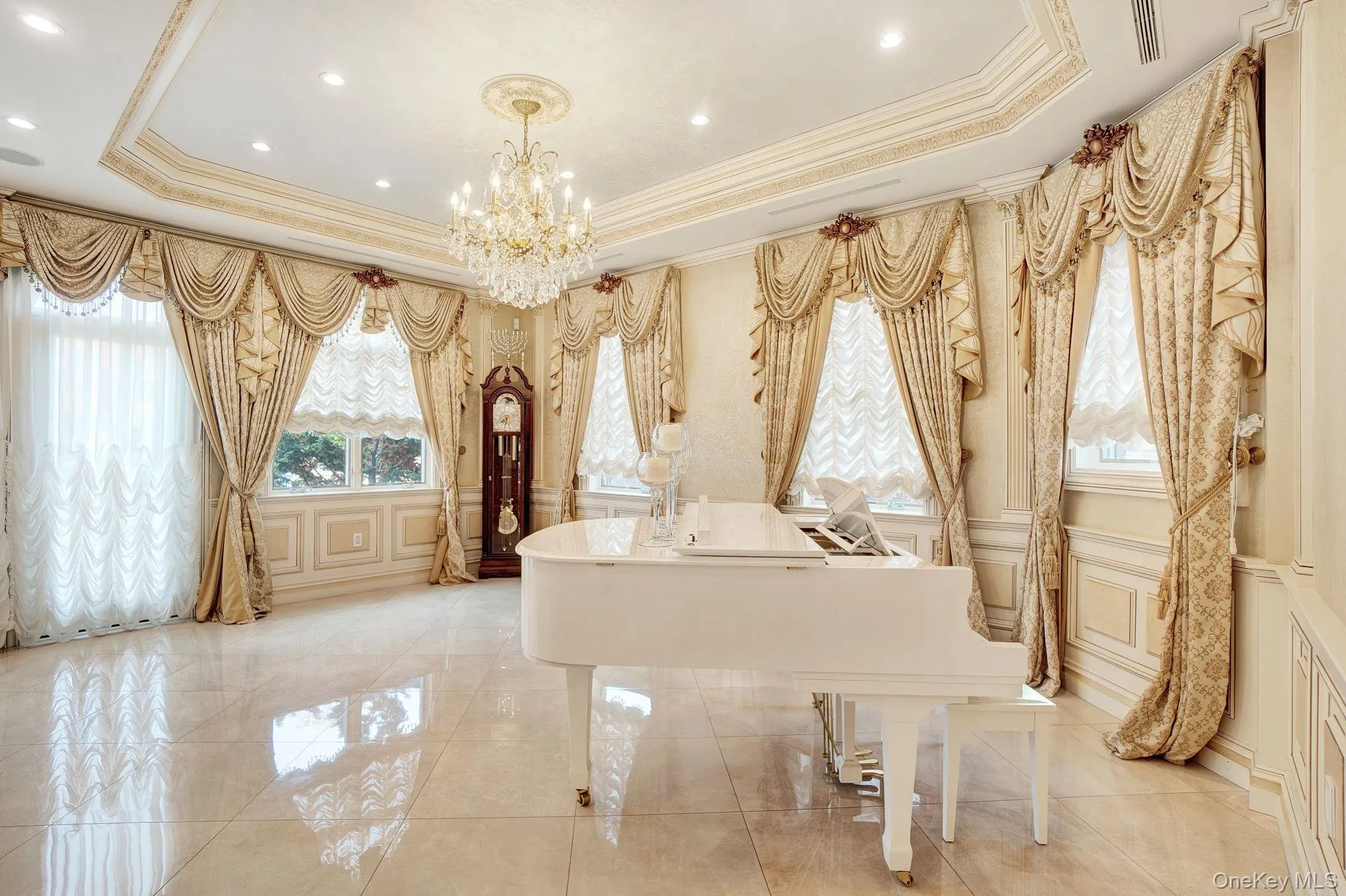 Full bath featuring a decorative wall, a raised ceiling, a chandelier, crown molding, and tile patterned floors Full bath featuring a decorative wall, a raised ceiling, a chandelier, crown molding, and tile patterned floors