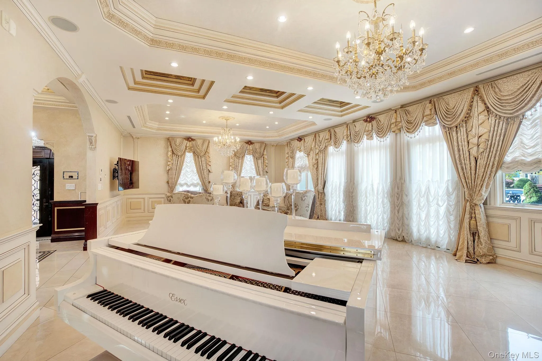 Bedroom featuring a decorative wall, a chandelier, ornamental molding, multiple windows, and a wainscoted wall Bedroom featuring a decorative wall, a chandelier, ornamental molding, multiple windows, and a wainscoted wall
