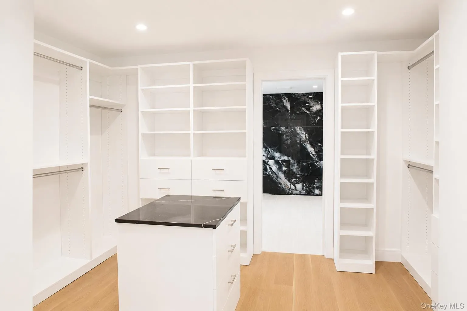 Custom closet system featuring white built-in shelving, hanging rods, and drawers Custom closet system featuring white built-in shelving, hanging rods, and drawers
