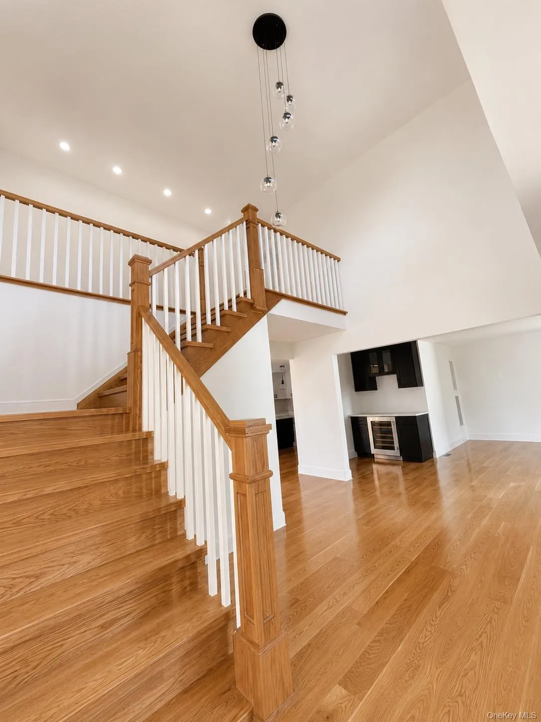 Two-story entryway with wood-finish flooring and a matching staircase Two-story entryway with wood-finish flooring and a matching staircase