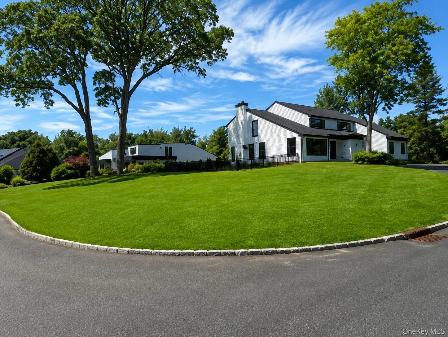 Modern white exterior with dark trim and a prominent black roofline Modern white exterior with dark trim and a prominent black roofline