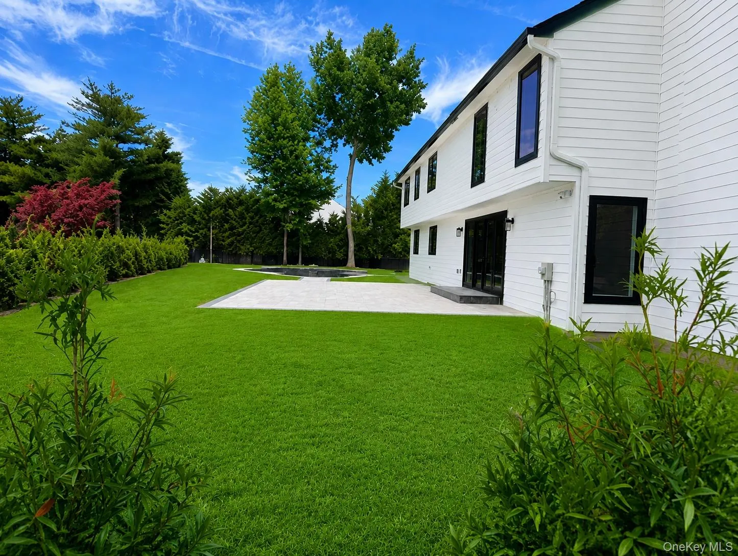 Rear exterior featuring white horizontal siding and black-framed windows Rear exterior featuring white horizontal siding and black-framed windows