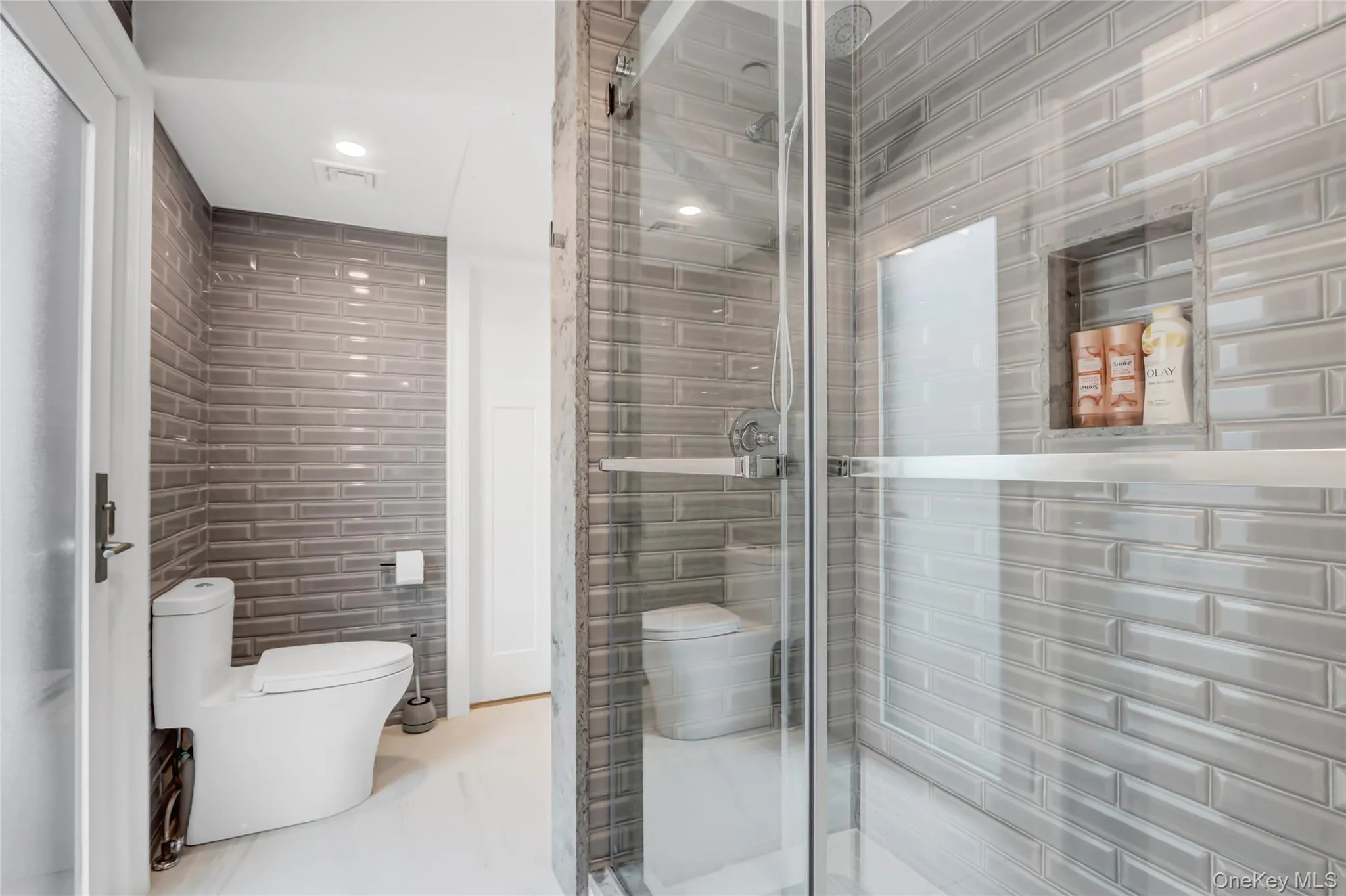 Full bath featuring tile walls, a stall shower, and recessed lighting Full bath featuring tile walls, a stall shower, and recessed lighting
