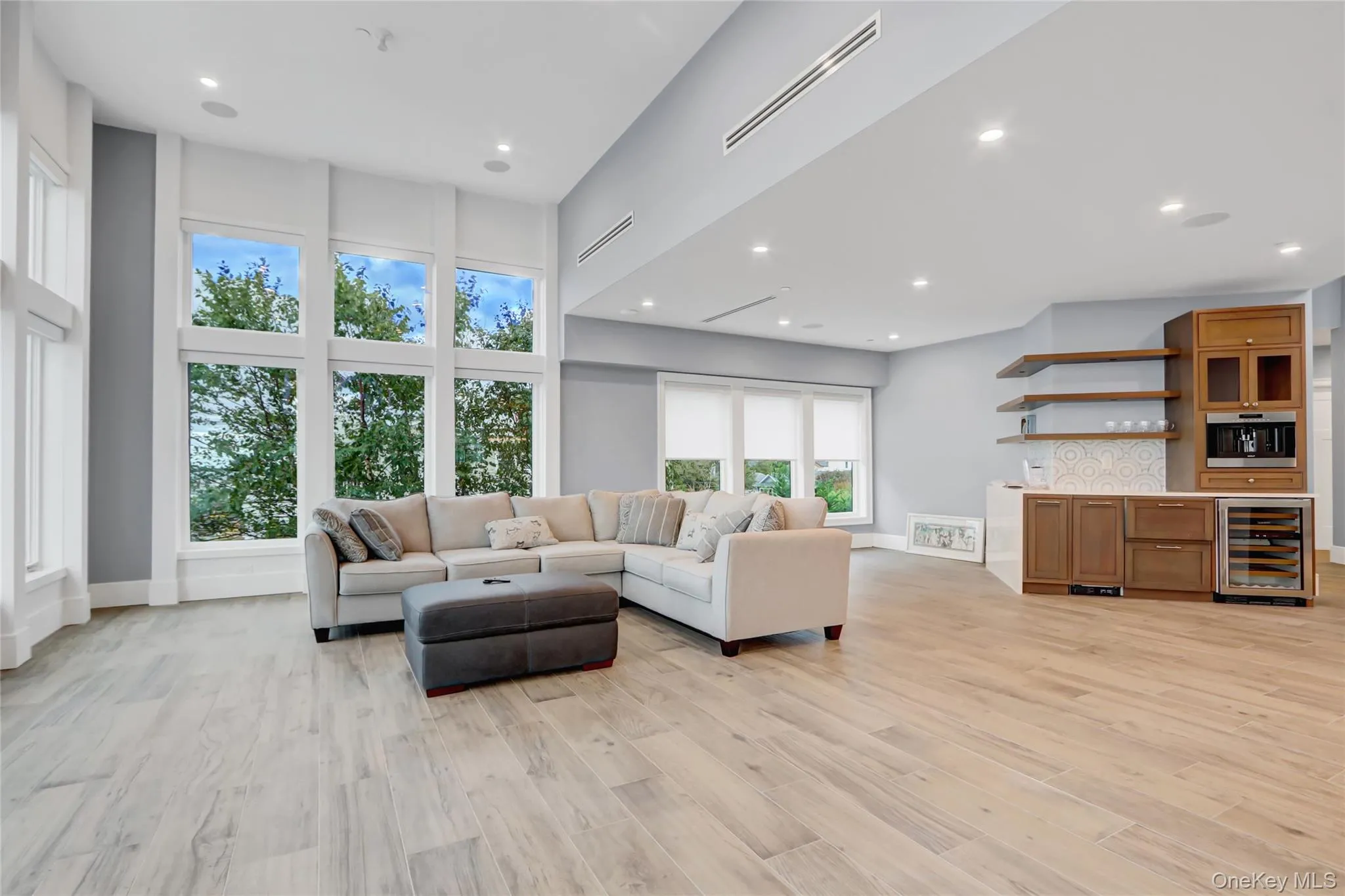 Living area with recessed lighting, light wood-style flooring, wine cooler, and bar area Living area with recessed lighting, light wood-style flooring, wine cooler, and bar area