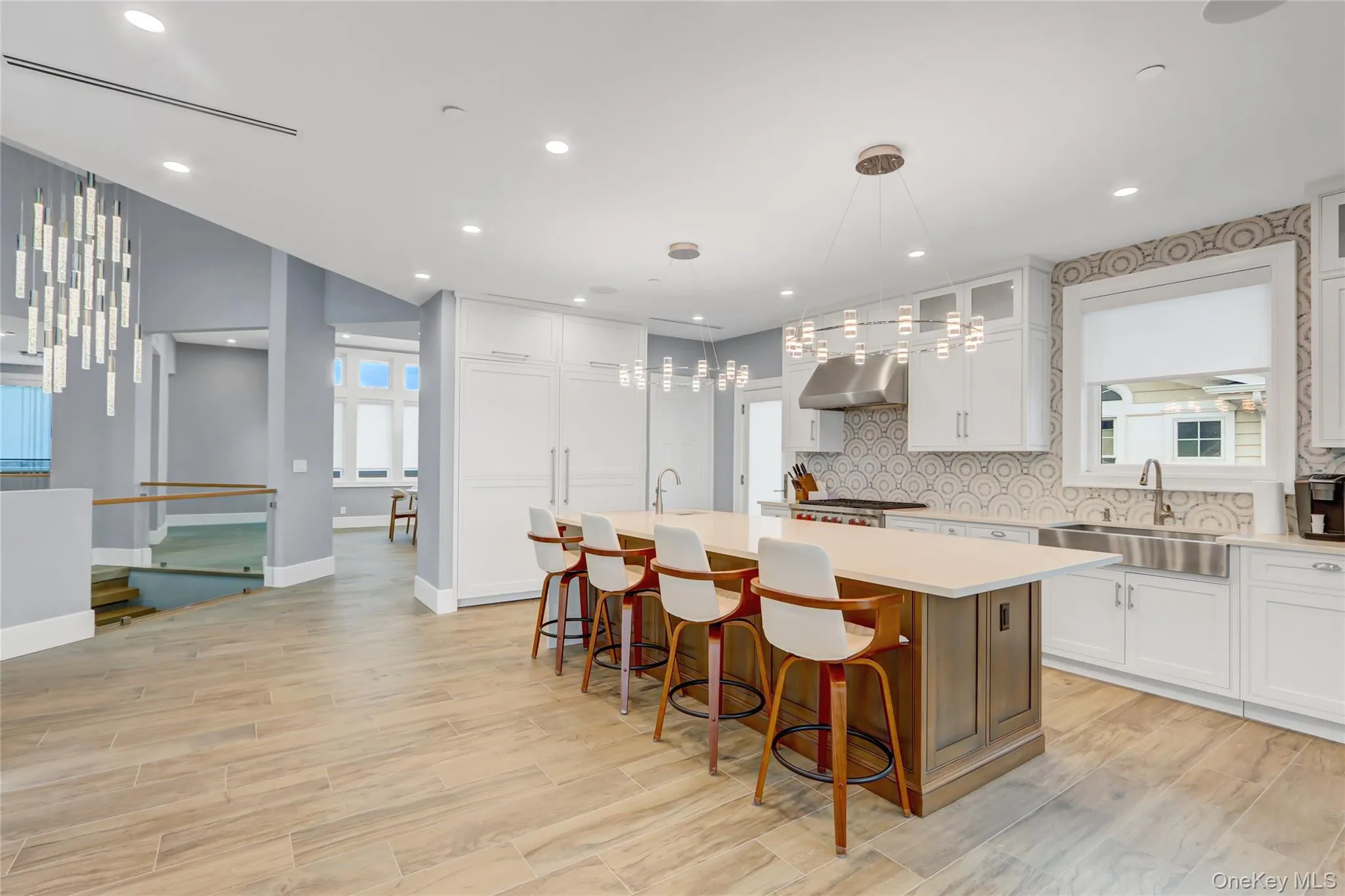 Kitchen featuring a kitchen island with sink, tasteful backsplash, plenty of natural light, a kitchen breakfast bar, and recessed lighting Kitchen featuring a kitchen island with sink, tasteful backsplash, plenty of natural light, a kitchen breakfast bar, and recessed lighting