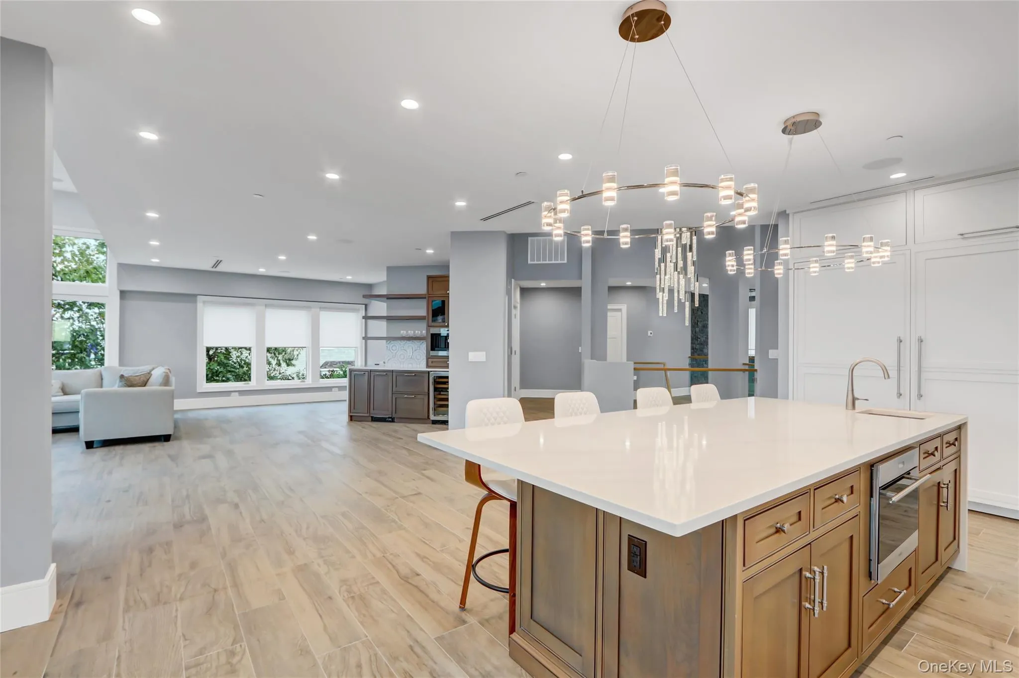 Kitchen featuring a breakfast bar, a spacious island, brown cabinets, open floor plan, and light wood-type flooring Kitchen featuring a breakfast bar, a spacious island, brown cabinets, open floor plan, and light wood-type flooring