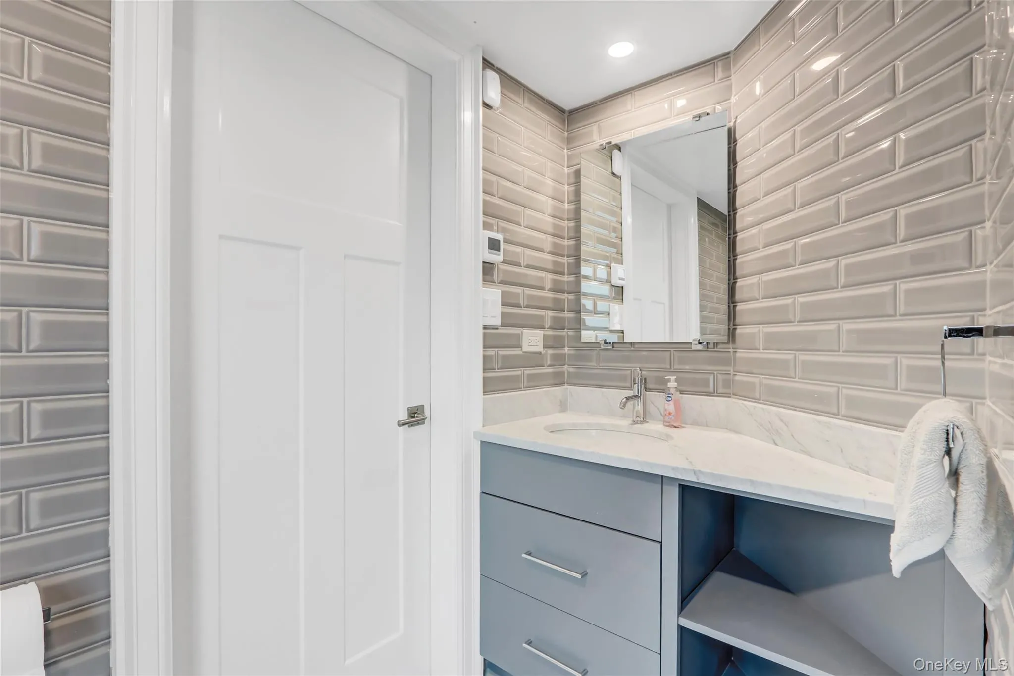 Bathroom featuring vanity and decorative backsplash Bathroom featuring vanity and decorative backsplash