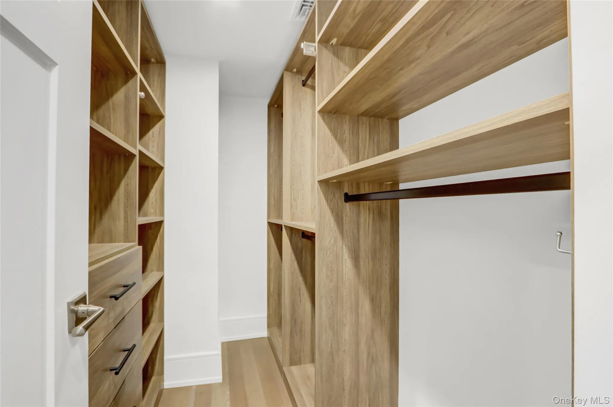 Spacious closet with light wood-type flooring Spacious closet with light wood-type flooring