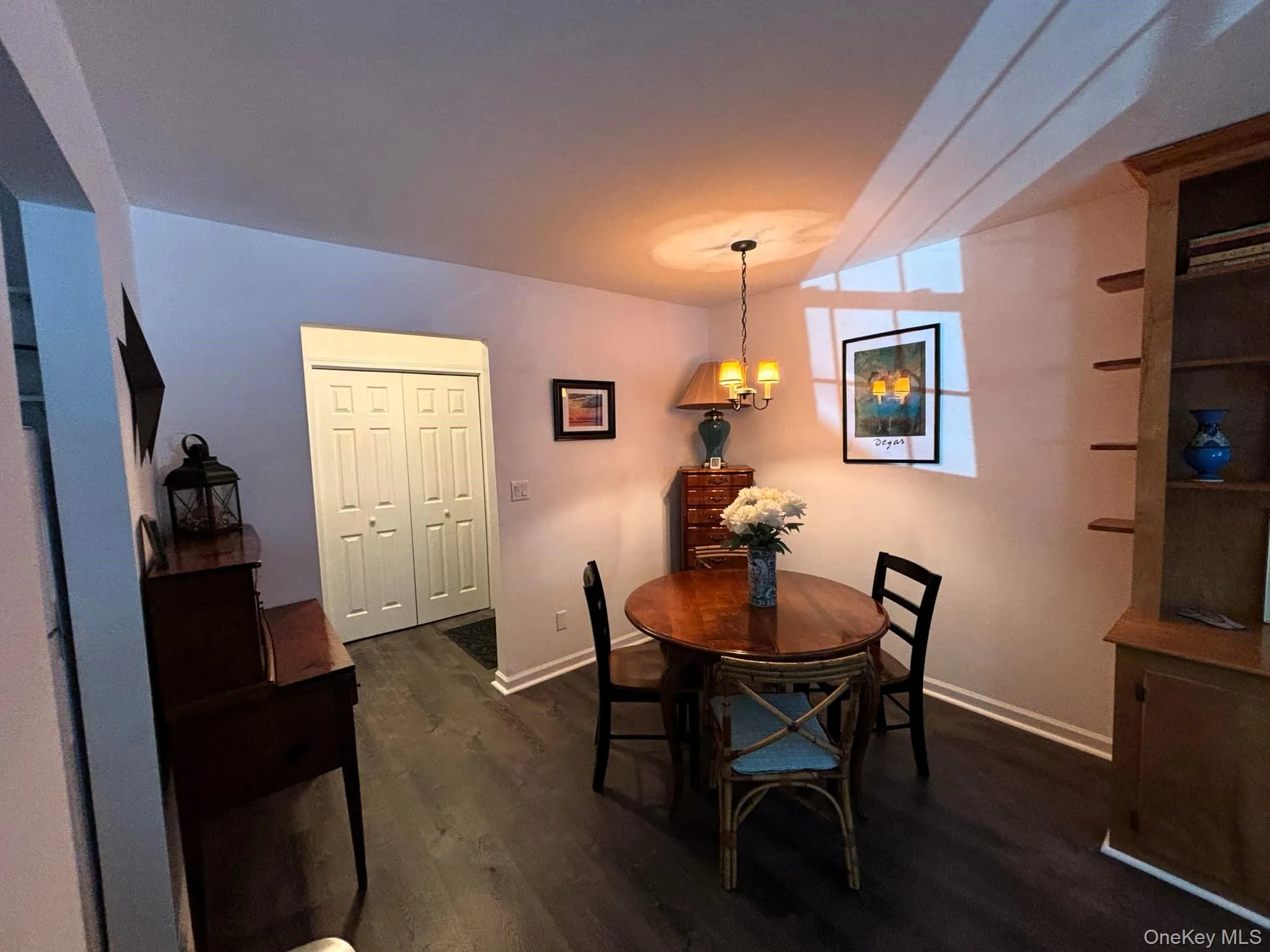 Dining space with dark wood-style floors and a chandelier Dining space with dark wood-style floors and a chandelier