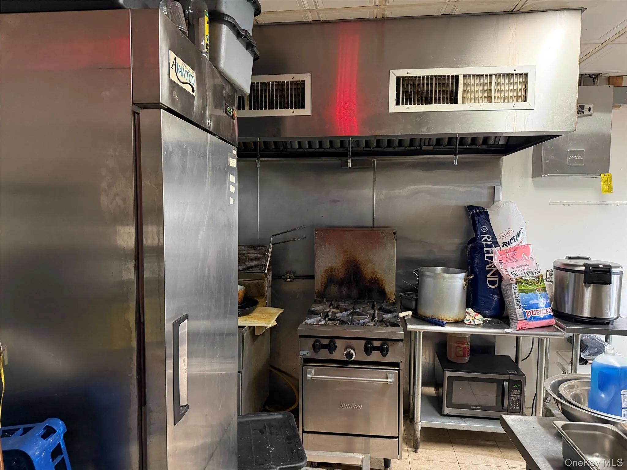 Kitchen featuring appliances with stainless steel finishes, extractor fan, and tile patterned floors Kitchen featuring appliances with stainless steel finishes, extractor fan, and tile patterned floors