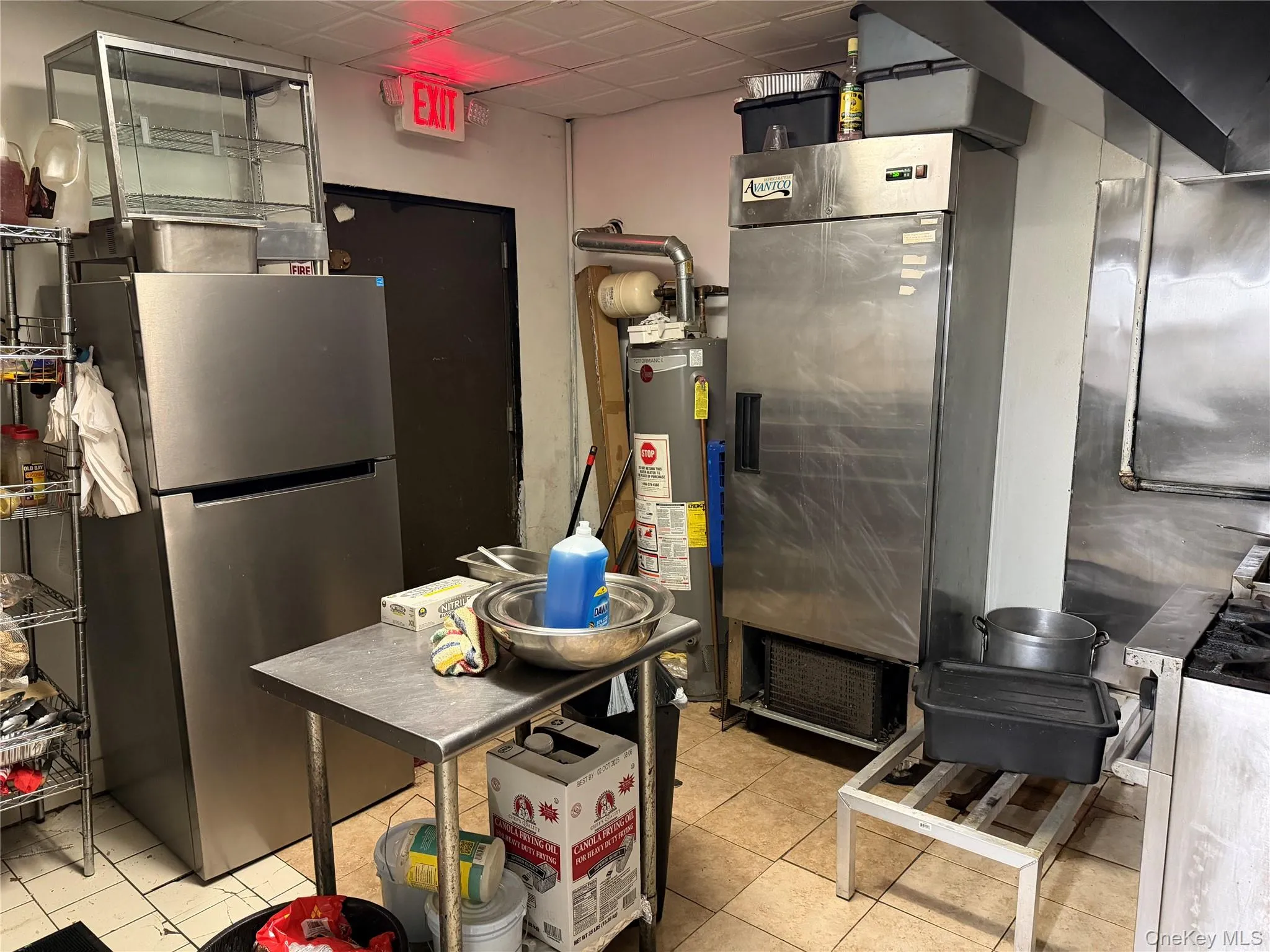 Kitchen featuring freestanding refrigerator, a paneled ceiling, gas water heater, and heating unit Kitchen featuring freestanding refrigerator, a paneled ceiling, gas water heater, and heating unit