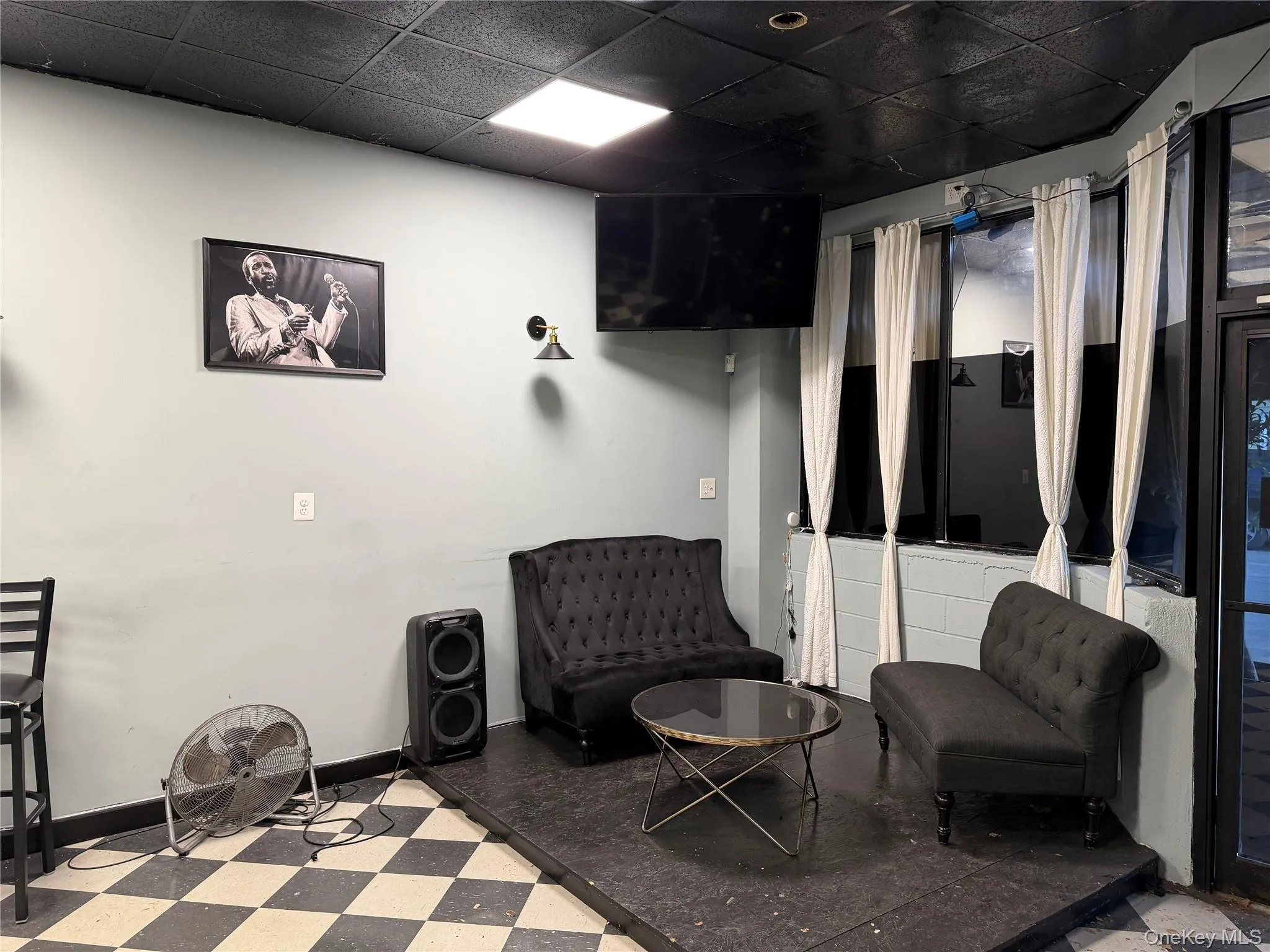 Living area featuring a drop ceiling and tile patterned floors Living area featuring a drop ceiling and tile patterned floors