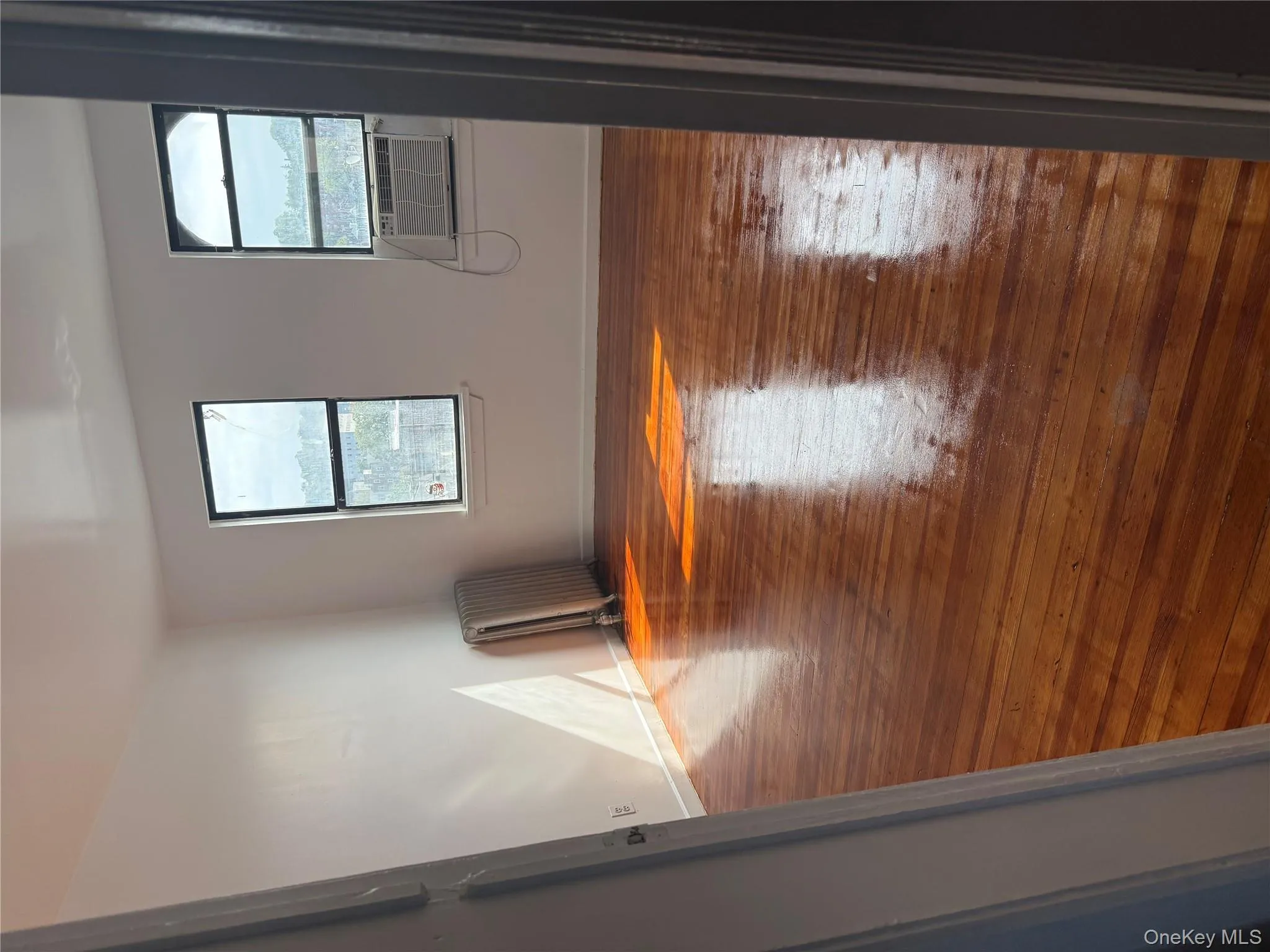 Spare room featuring hardwood / wood-style flooring, plenty of natural light, and radiator Spare room featuring hardwood / wood-style flooring, plenty of natural light, and radiator