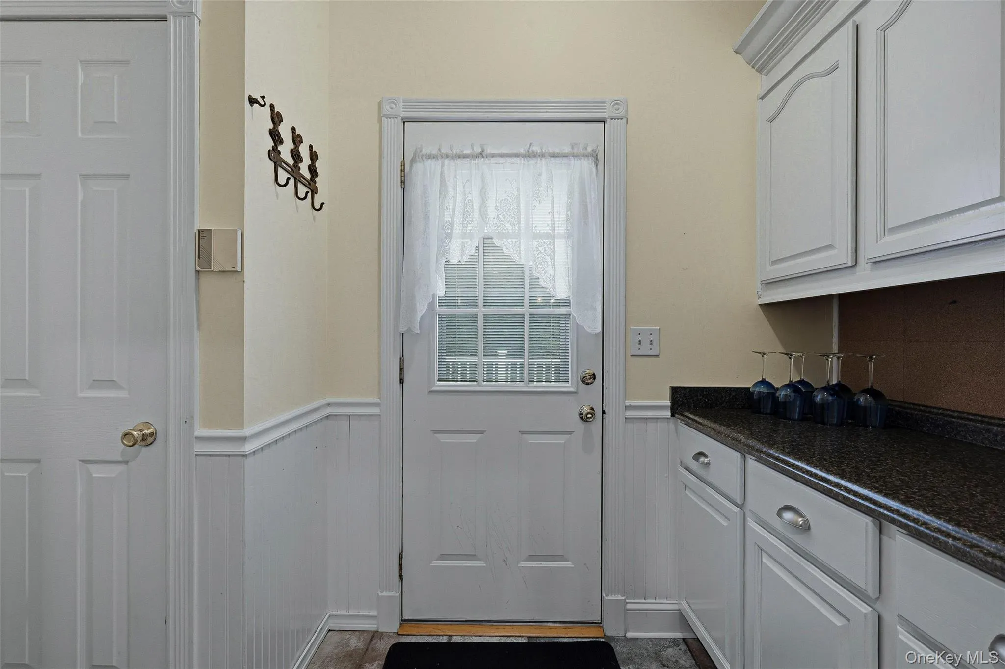 Doorway to outside with a wainscoted wall Doorway to outside with a wainscoted wall