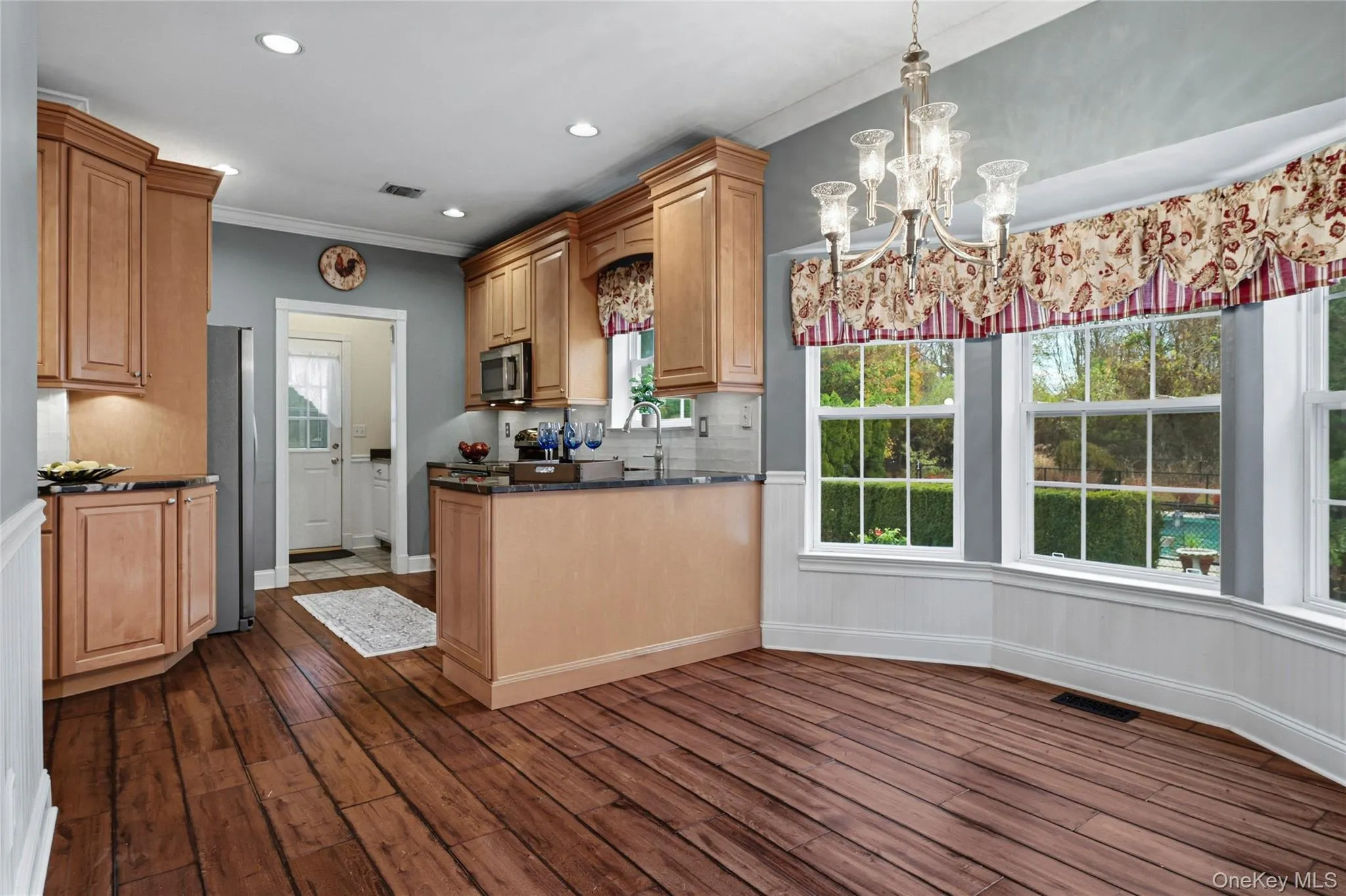 Kitchen with healthy amount of natural light, backsplash, crown molding, hanging light fixtures, and recessed lighting Kitchen with healthy amount of natural light, backsplash, crown molding, hanging light fixtures, and recessed lighting