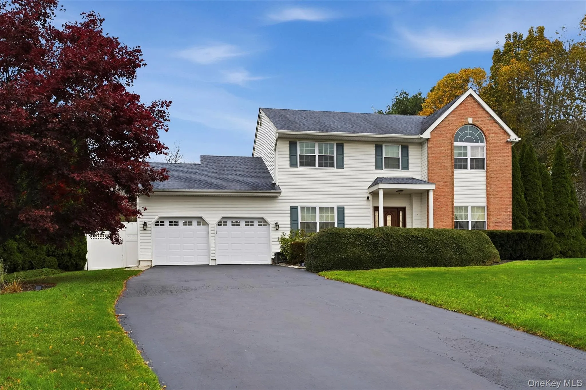 View of front facade with a front lawn, asphalt driveway, a shingled roof, and a garage View of front facade with a front lawn, asphalt driveway, a shingled roof, and a garage