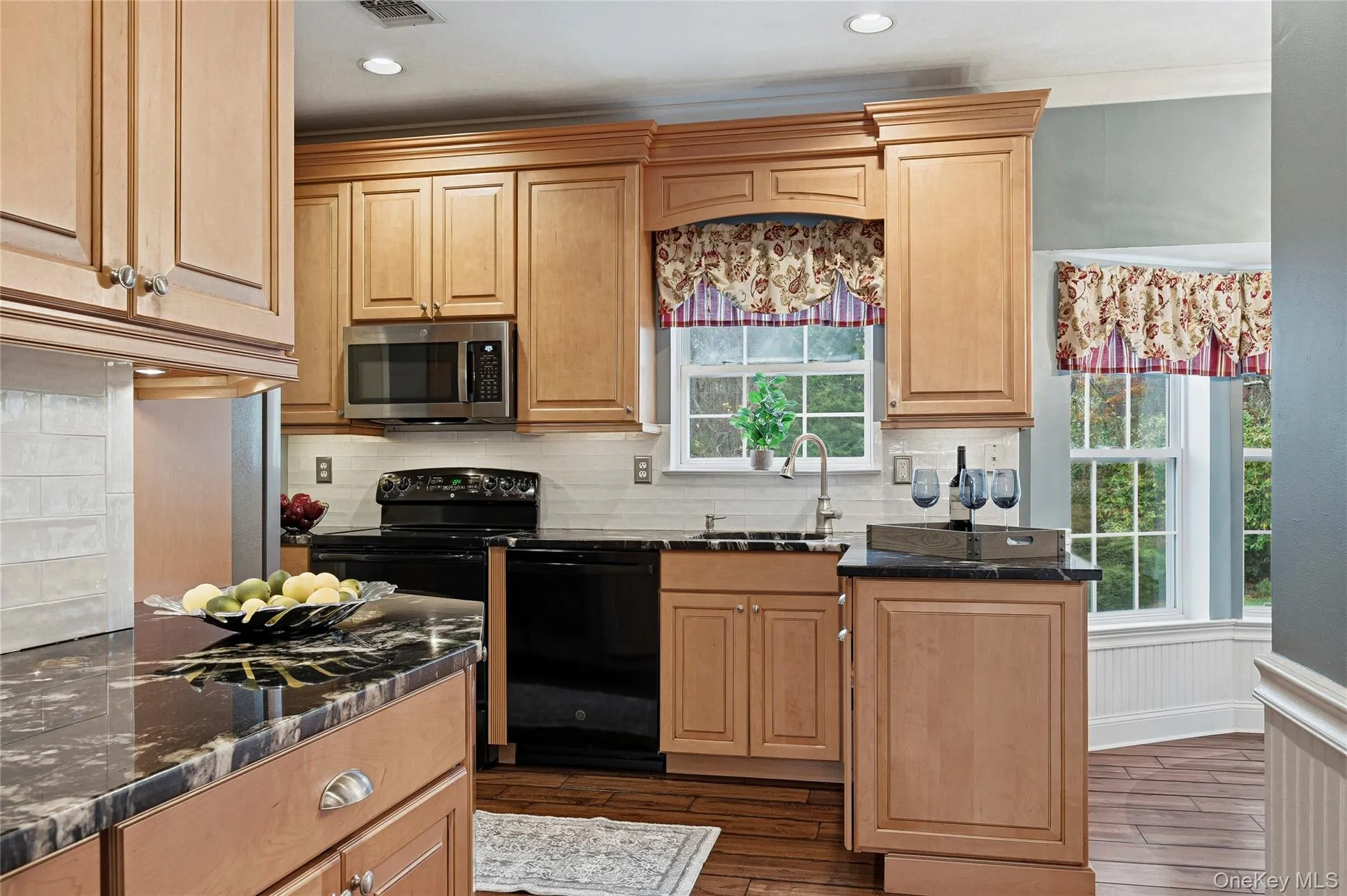 Kitchen with backsplash, dark stone counters, dishwasher, and recessed lighting Kitchen with backsplash, dark stone counters, dishwasher, and recessed lighting