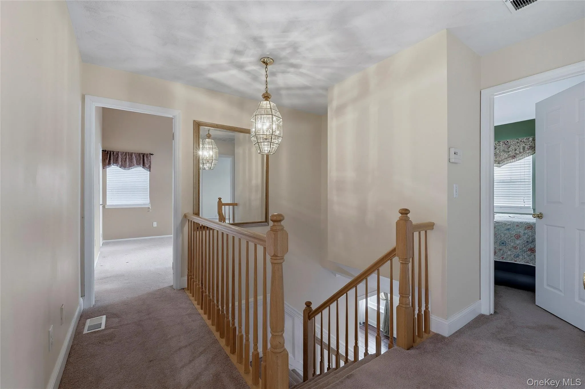 Corridor featuring an upstairs landing, carpet flooring, and plenty of natural light Corridor featuring an upstairs landing, carpet flooring, and plenty of natural light