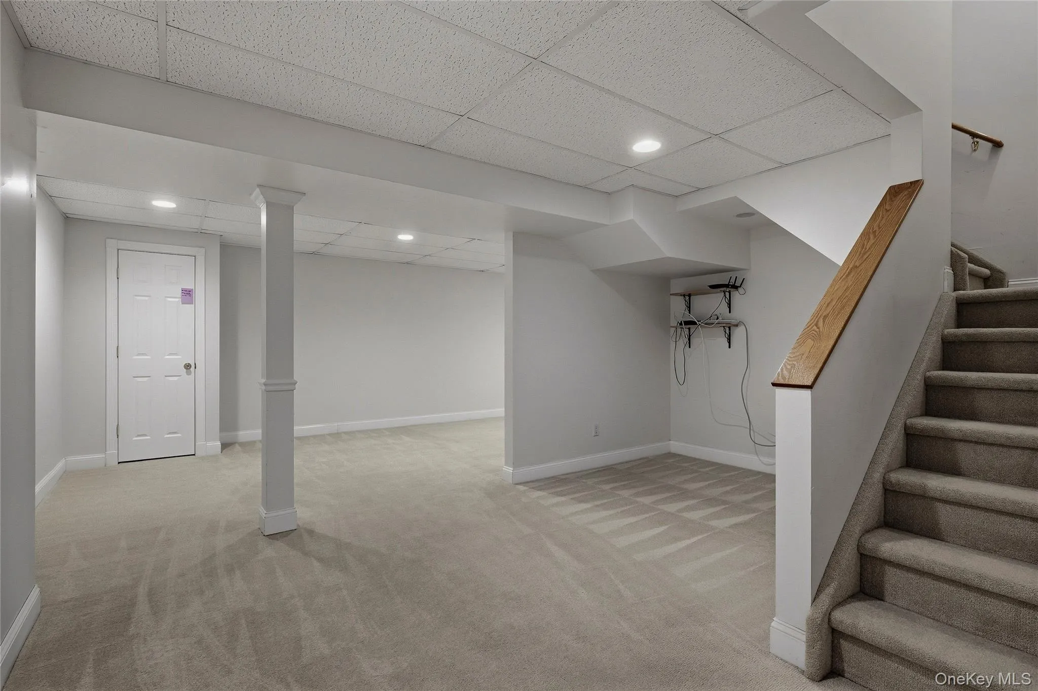 Finished basement with light carpet, a drop ceiling, stairs, and recessed lighting Finished basement with light carpet, a drop ceiling, stairs, and recessed lighting