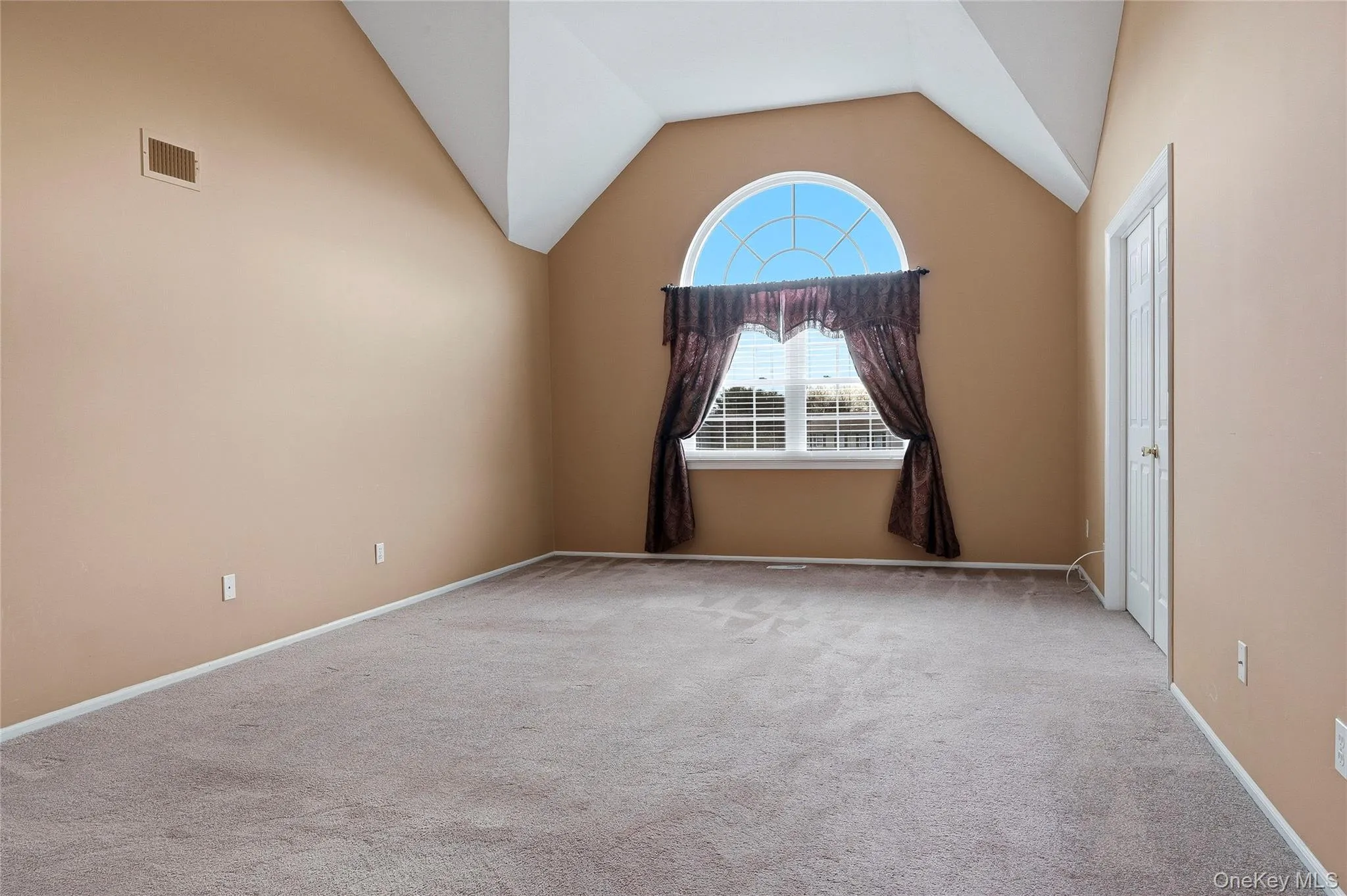 Carpeted spare room featuring lofted ceiling and baseboards Carpeted spare room featuring lofted ceiling and baseboards
