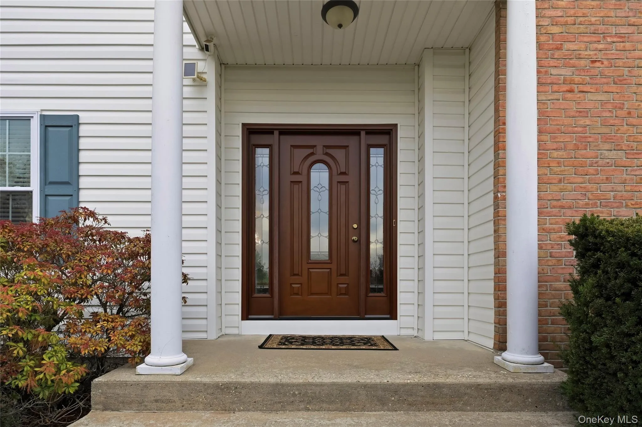 Property entrance with covered porch and brick siding Property entrance with covered porch and brick siding
