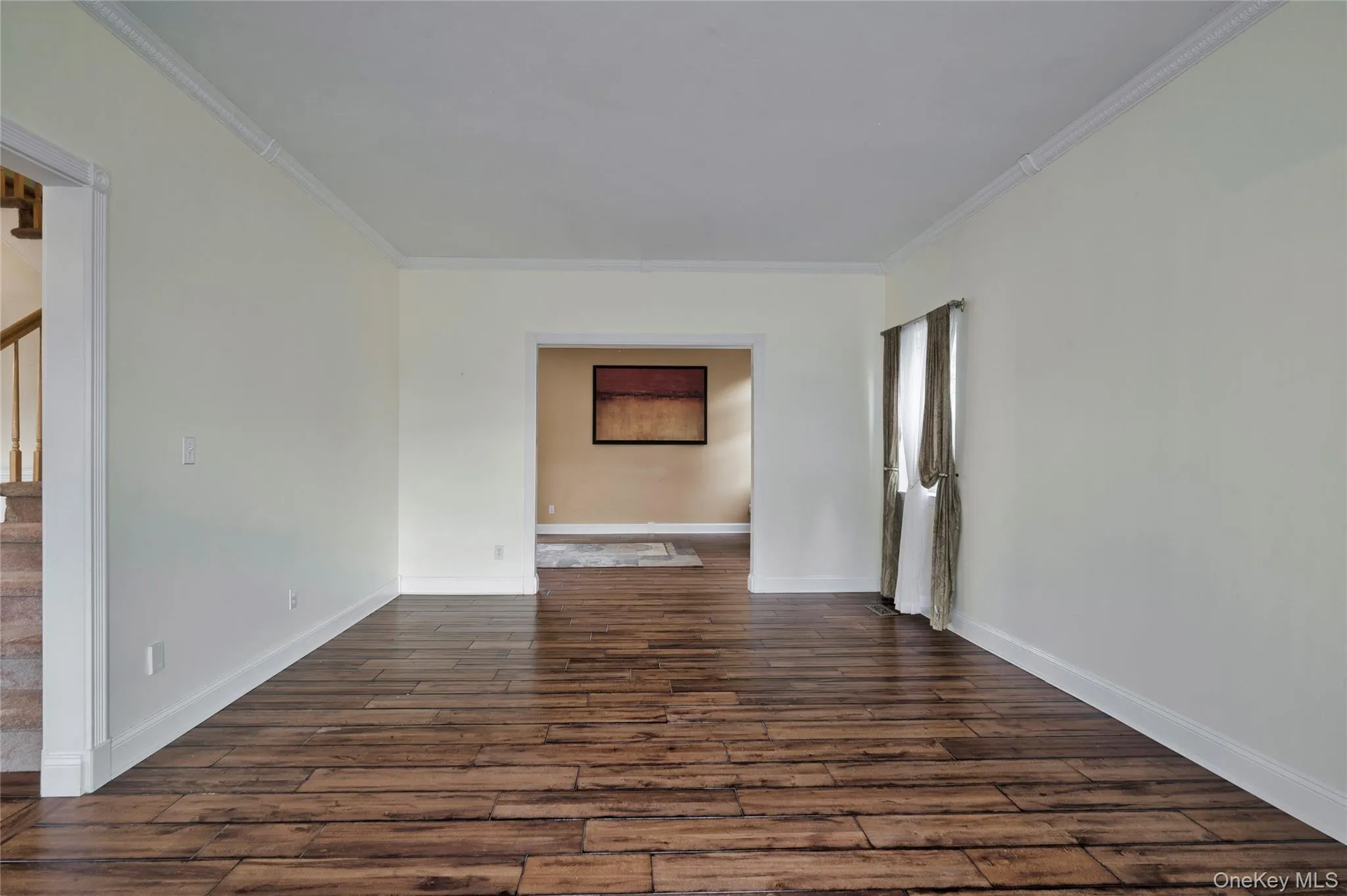 Unfurnished room with crown molding, stairway, and dark wood-style flooring Unfurnished room with crown molding, stairway, and dark wood-style flooring