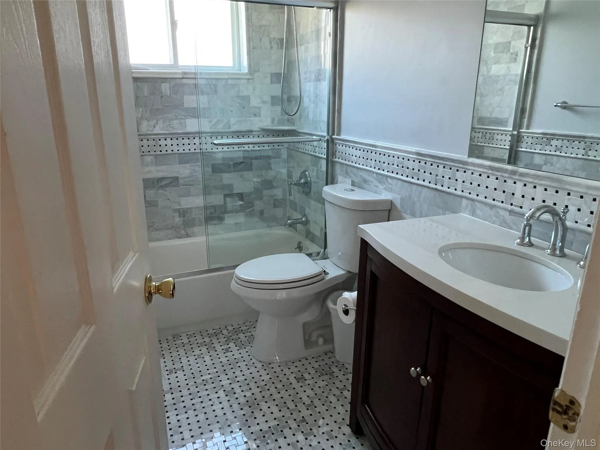 Full bathroom featuring vanity, enclosed tub / shower combo, and tile walls Full bathroom featuring vanity, enclosed tub / shower combo, and tile walls