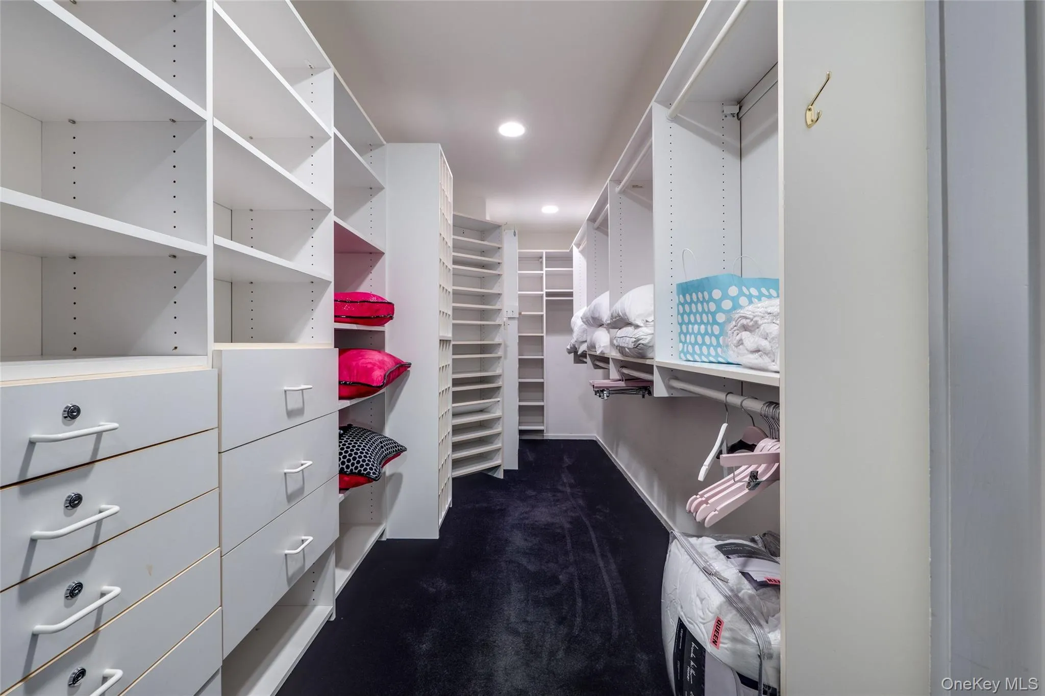 Walk in closet featuring dark colored carpet Walk in closet featuring dark colored carpet