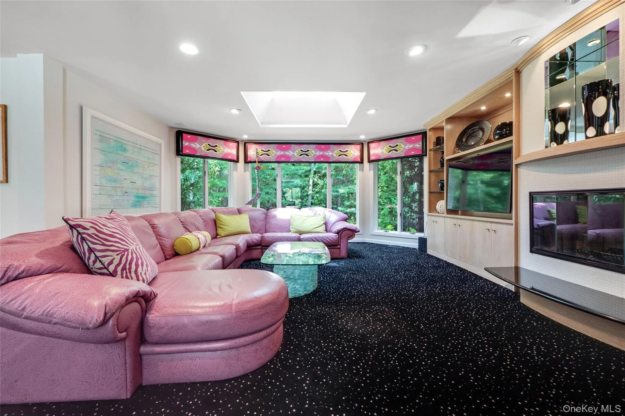 Living room featuring a skylight, recessed lighting, carpet flooring, and built in features Living room featuring a skylight, recessed lighting, carpet flooring, and built in features