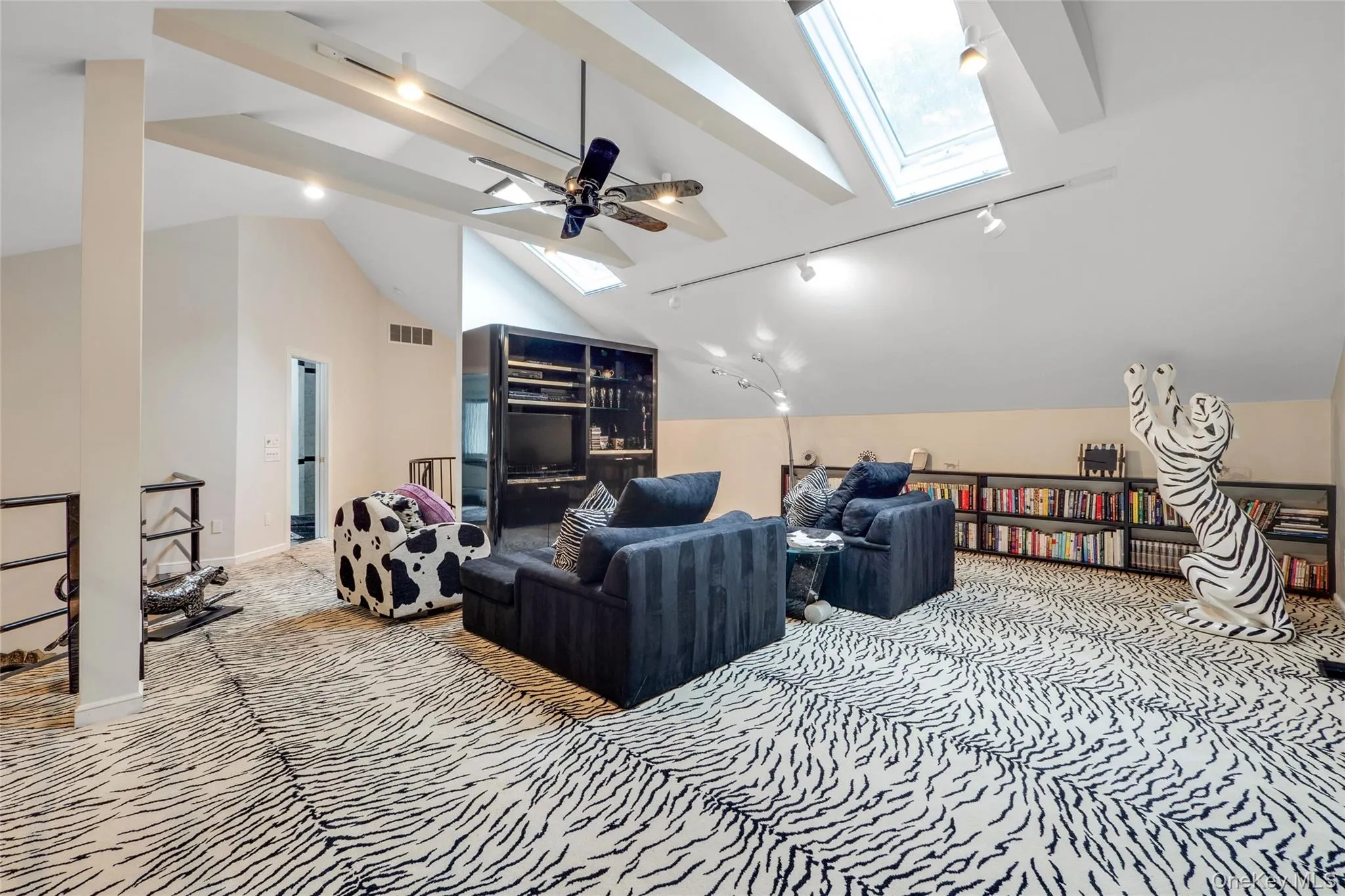 Carpeted cinema room featuring a skylight, track lighting, and a ceiling fan Carpeted cinema room featuring a skylight, track lighting, and a ceiling fan
