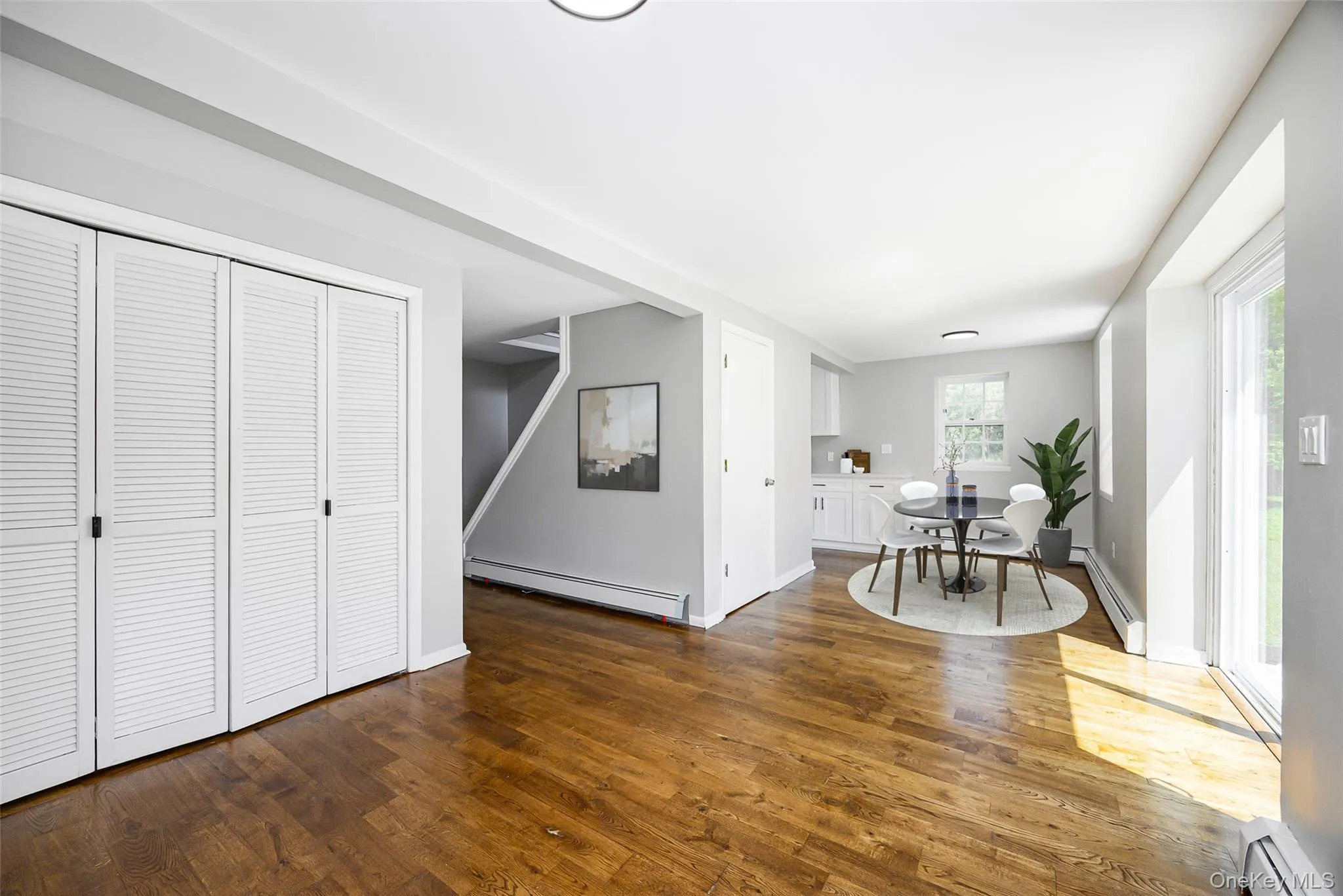 Dining room with dark wood-style flooring and a baseboard heating unit Dining room with dark wood-style flooring and a baseboard heating unit