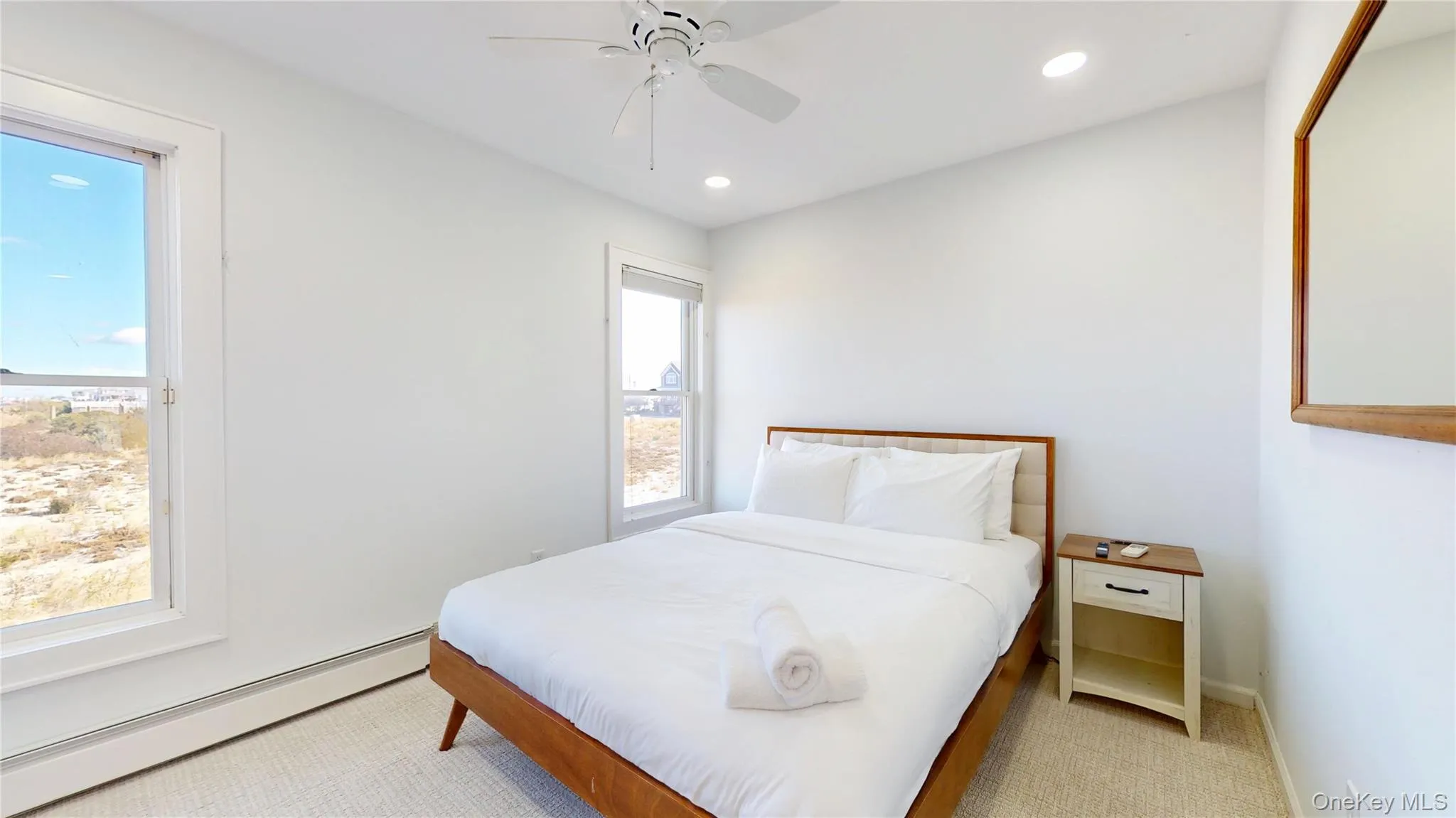Bedroom with a baseboard radiator, ceiling fan, recessed lighting, and light carpet Bedroom with a baseboard radiator, ceiling fan, recessed lighting, and light carpet