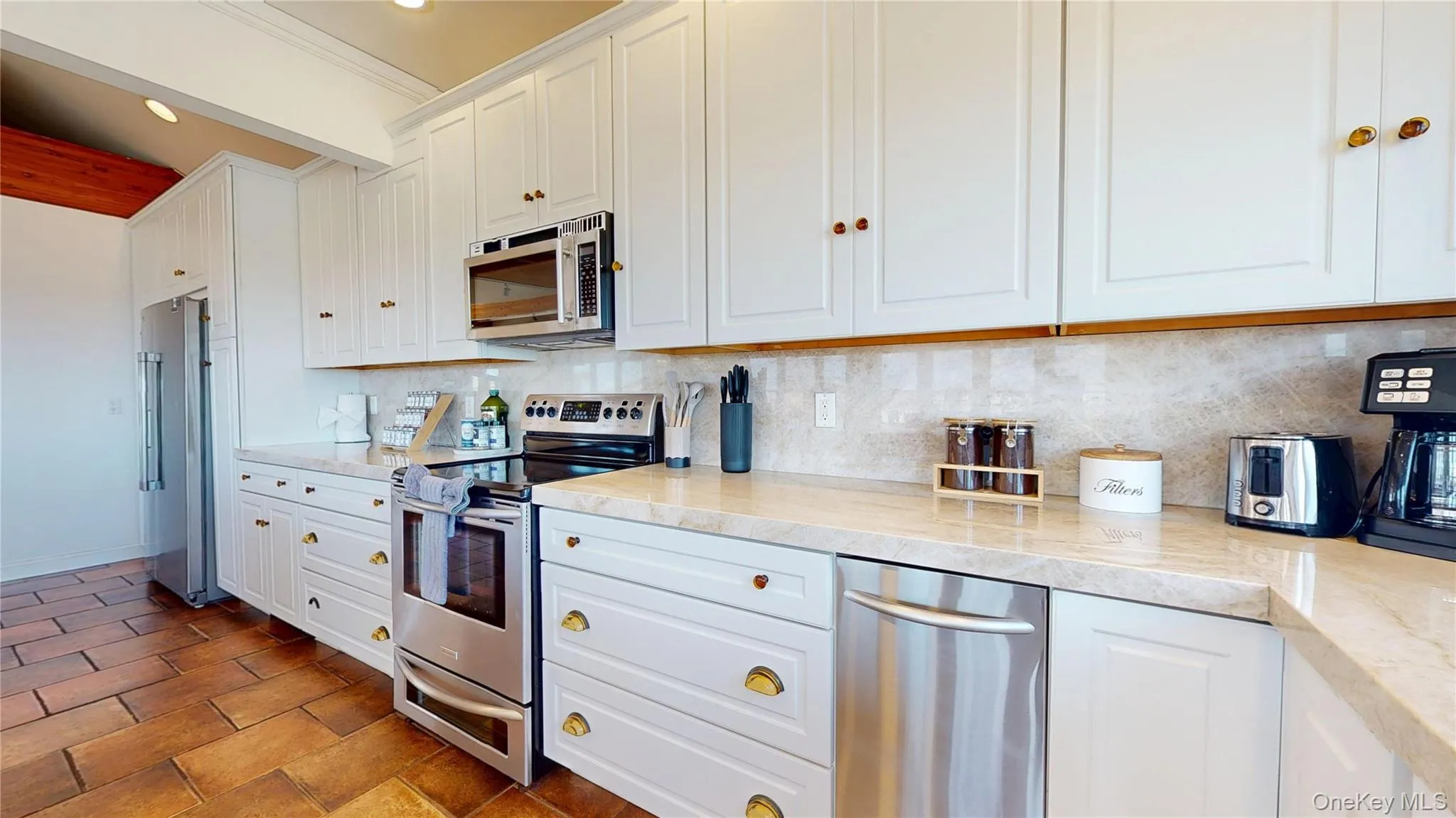 Kitchen with stainless steel appliances, decorative backsplash, white cabinets, light stone counters, and recessed lighting Kitchen with stainless steel appliances, decorative backsplash, white cabinets, light stone counters, and recessed lighting