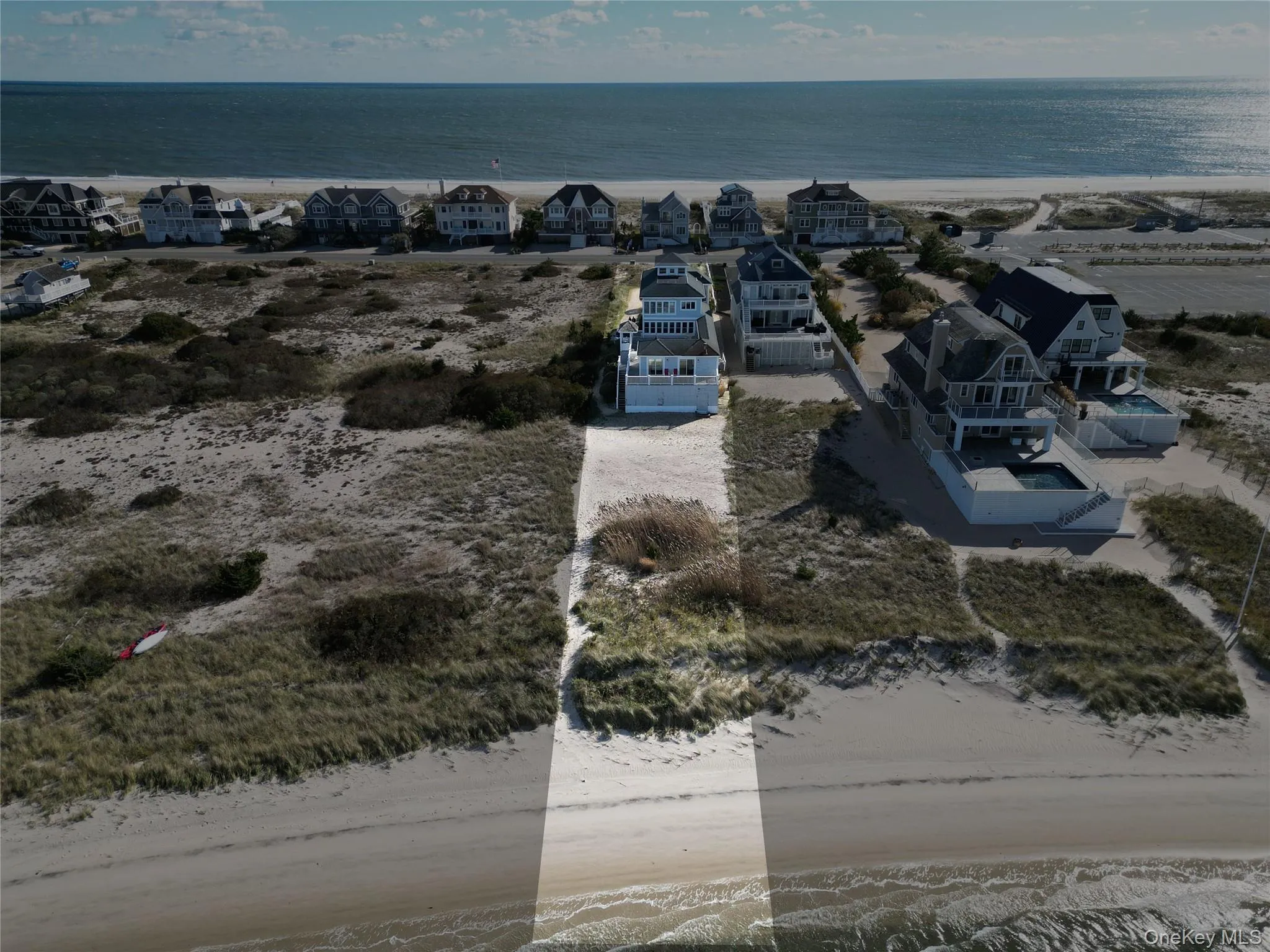 Aerial view of residential area featuring waterfront with a beach Aerial view of residential area featuring waterfront with a beach