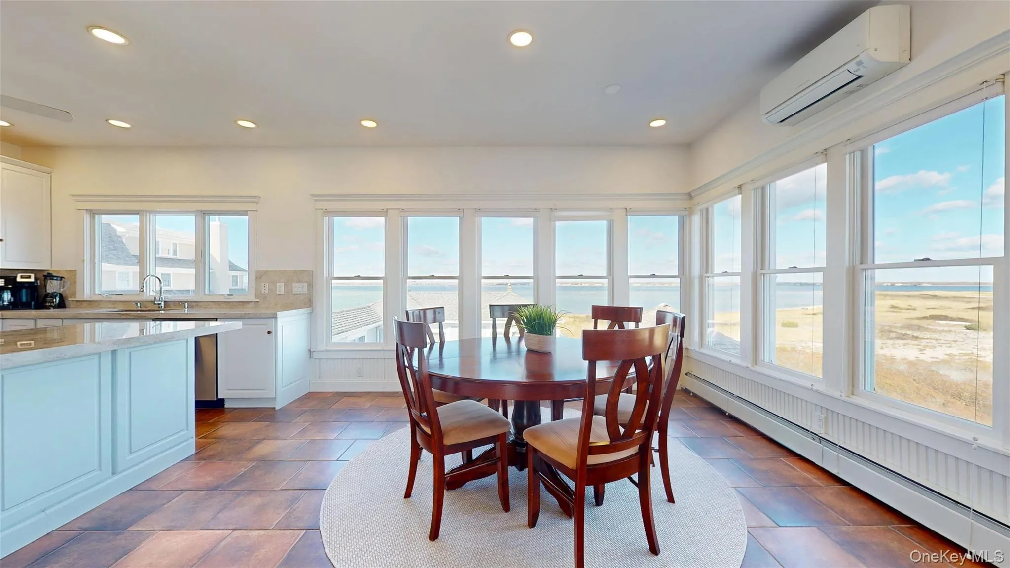 Dining room with a baseboard heating unit, a wall mounted air conditioner, a water view, and recessed lighting Dining room with a baseboard heating unit, a wall mounted air conditioner, a water view, and recessed lighting