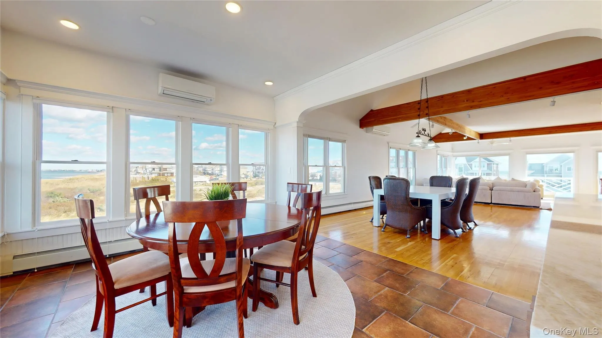 Dining space with baseboard heating, a wall mounted AC, recessed lighting, beamed ceiling, and crown molding Dining space with baseboard heating, a wall mounted AC, recessed lighting, beamed ceiling, and crown molding