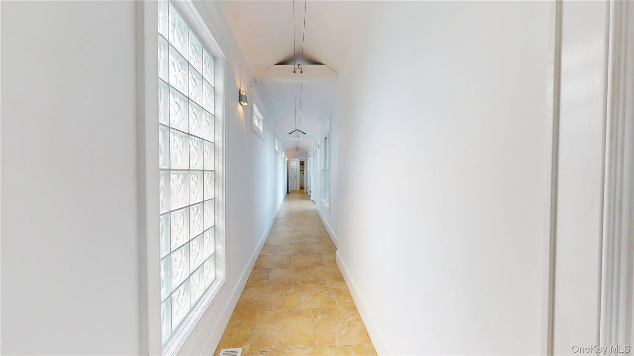 Hall with baseboards and lofted ceiling Hall with baseboards and lofted ceiling
