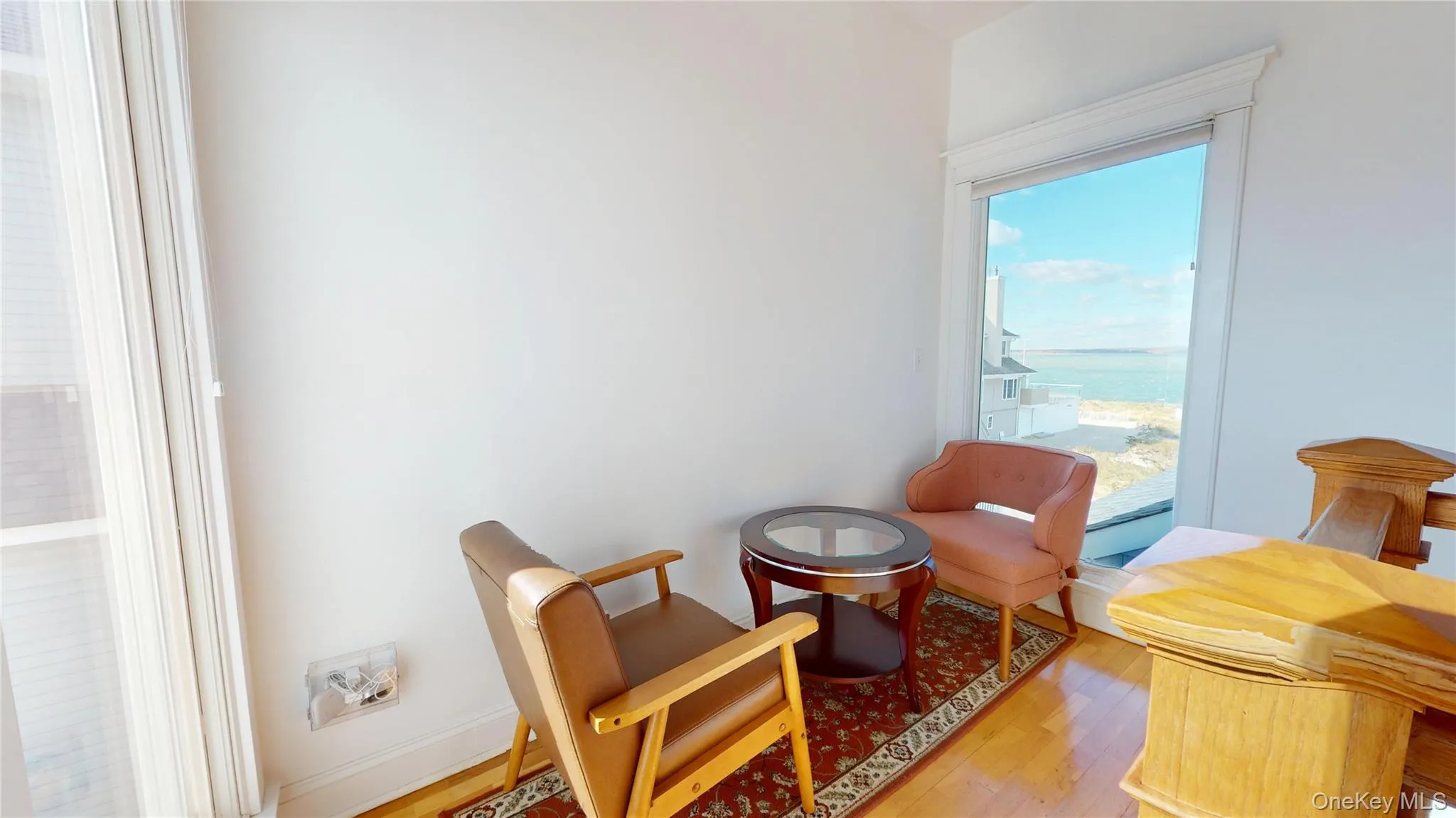 Sitting room featuring wood finished floors and a water view Sitting room featuring wood finished floors and a water view