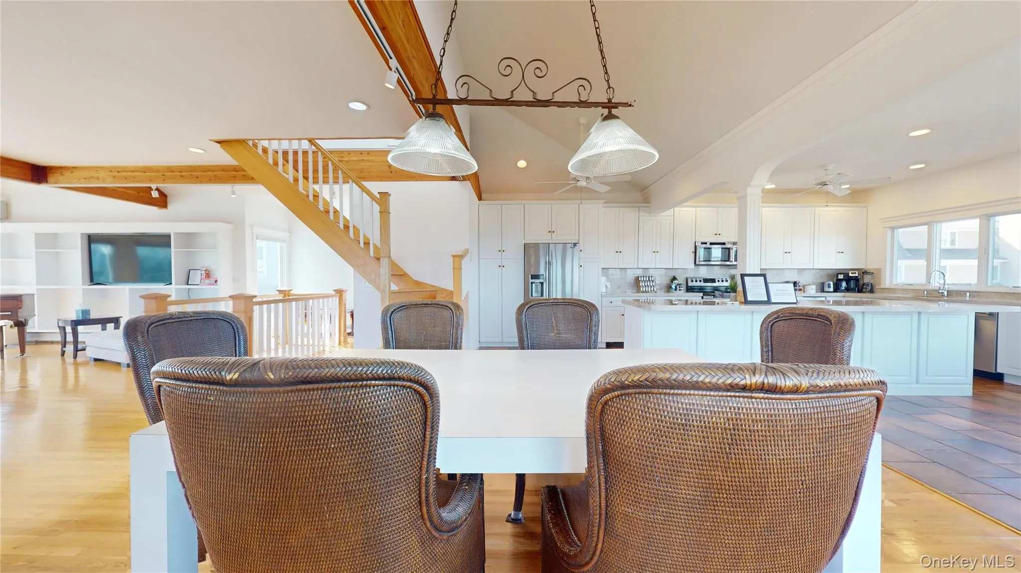 Dining space featuring light wood-type flooring, beamed ceiling, a ceiling fan, recessed lighting, and stairway Dining space featuring light wood-type flooring, beamed ceiling, a ceiling fan, recessed lighting, and stairway