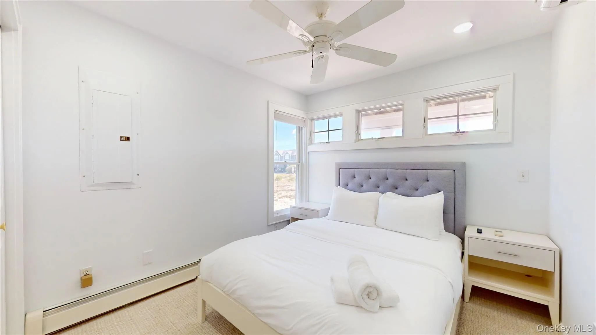 Carpeted bedroom with a baseboard heating unit, electric panel, ceiling fan, and recessed lighting Carpeted bedroom with a baseboard heating unit, electric panel, ceiling fan, and recessed lighting