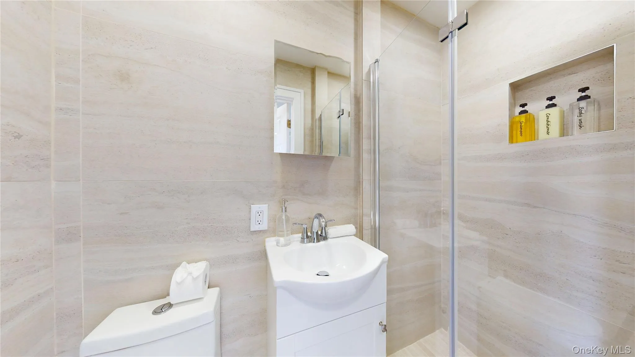 Bathroom with vanity, a stall shower, and tile walls Bathroom with vanity, a stall shower, and tile walls