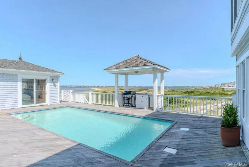 View of swimming pool featuring a gazebo, a wooden deck, and a grill View of swimming pool featuring a gazebo, a wooden deck, and a grill