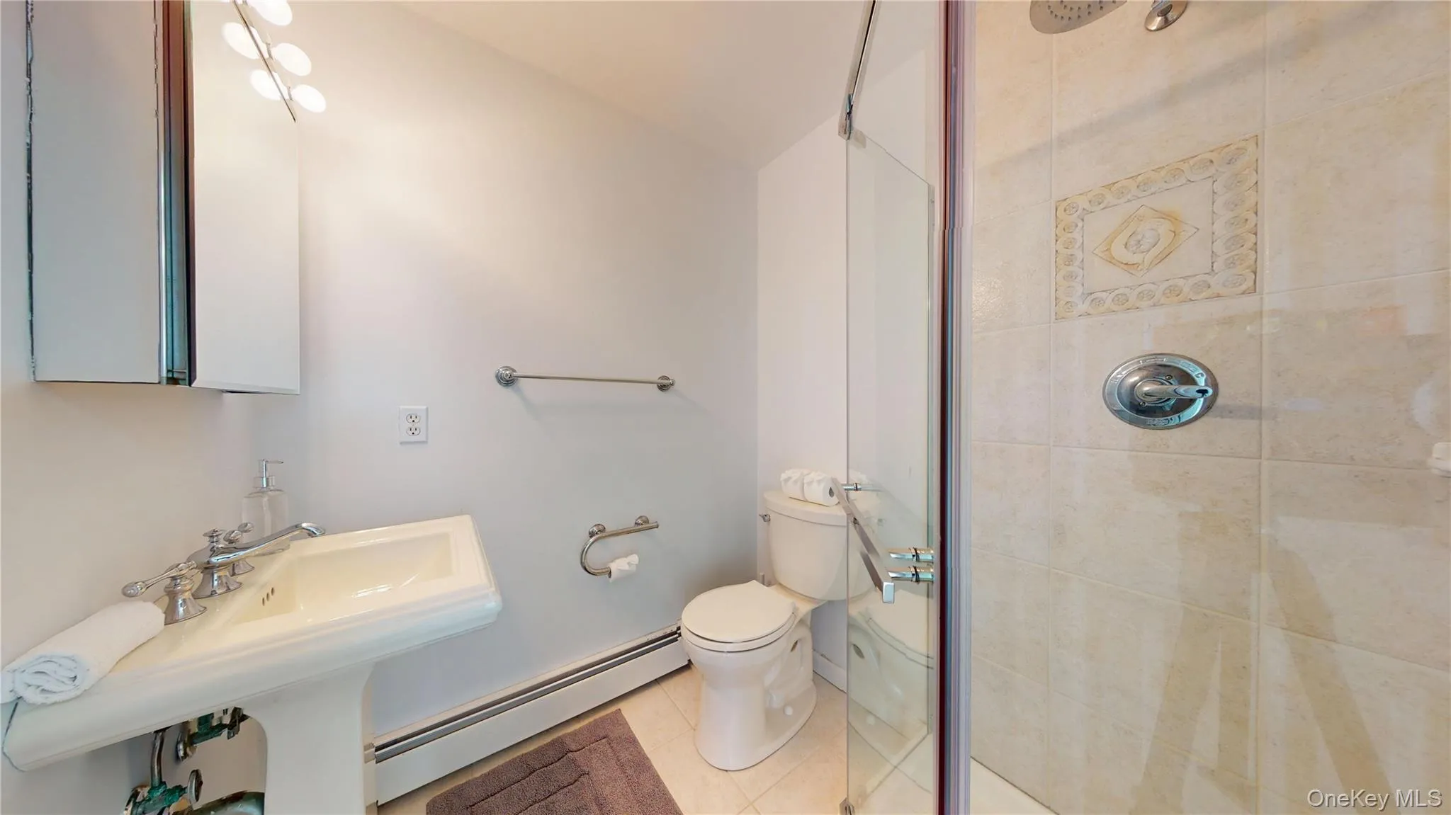 Full bath with a baseboard radiator, tile patterned flooring, and a shower stall Full bath with a baseboard radiator, tile patterned flooring, and a shower stall