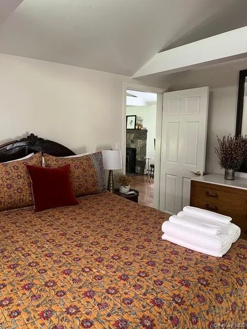 Bedroom featuring a fireplace and lofted ceiling Bedroom featuring a fireplace and lofted ceiling