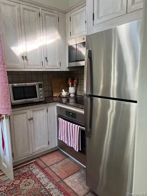 Kitchen with appliances with stainless steel finishes and decorative backsplash Kitchen with appliances with stainless steel finishes and decorative backsplash