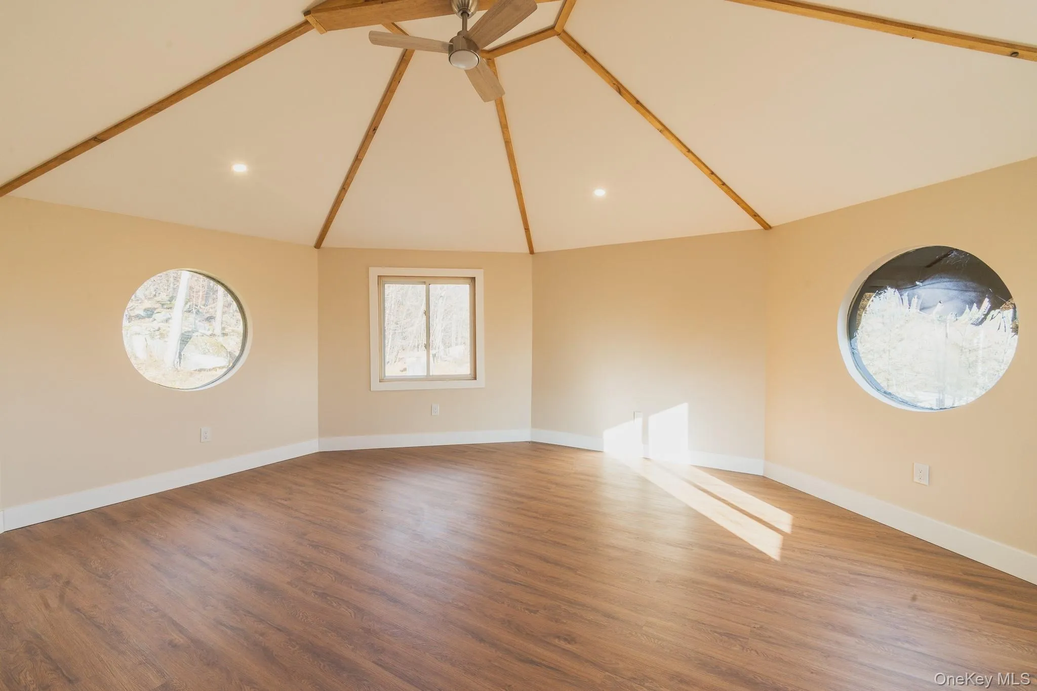 Unfurnished living room with light wood finished floors, recessed lighting, a ceiling fan, and high vaulted ceiling Unfurnished living room with light wood finished floors, recessed lighting, a ceiling fan, and high vaulted ceiling