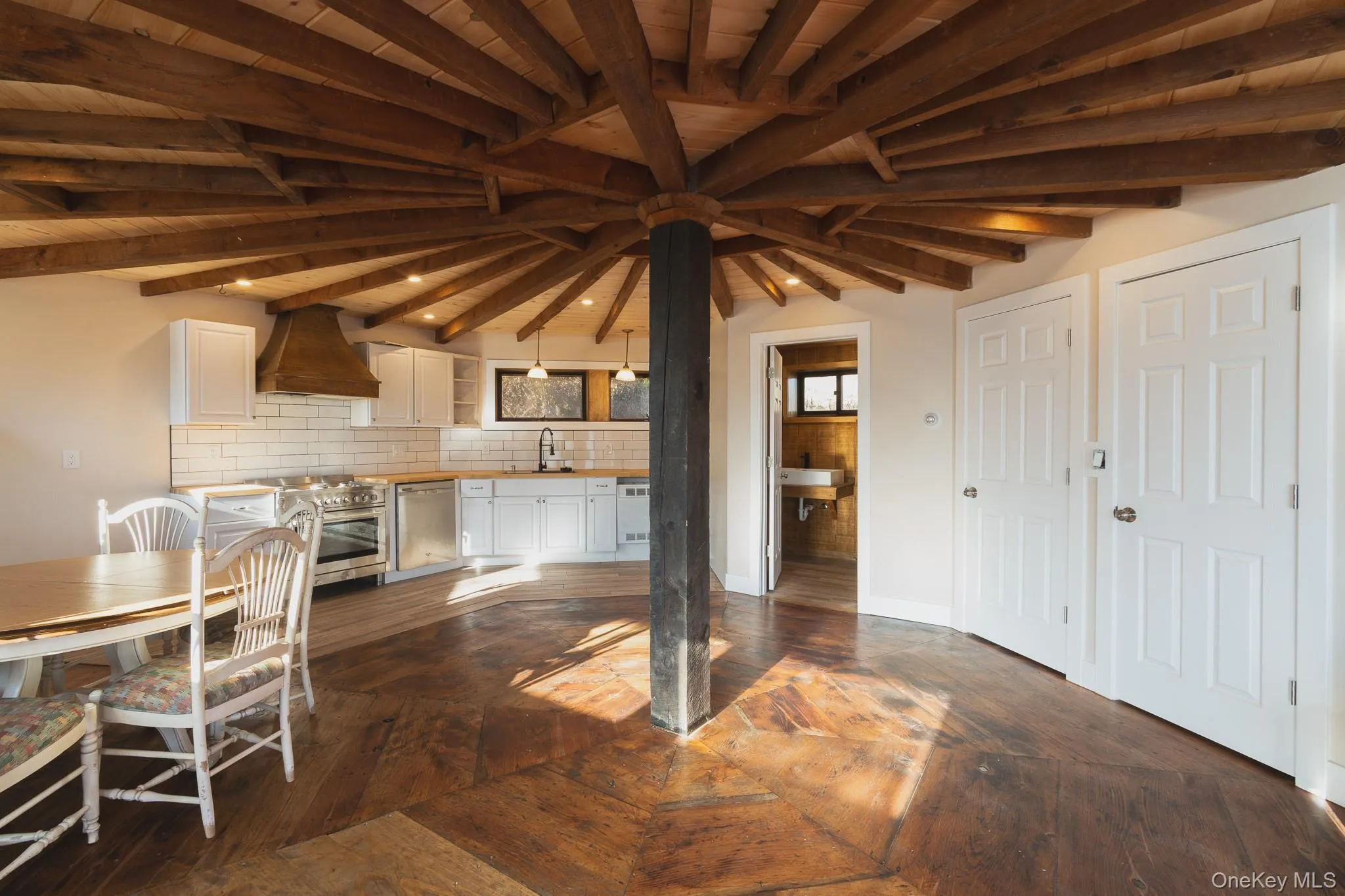 Unfurnished dining area featuring dark wood-type flooring and a wooden ceiling with exposed beams Unfurnished dining area featuring dark wood-type flooring and a wooden ceiling with exposed beams