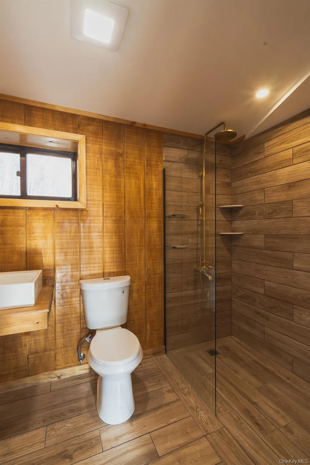 Bathroom featuring walk in shower and wood finished floors Bathroom featuring walk in shower and wood finished floors