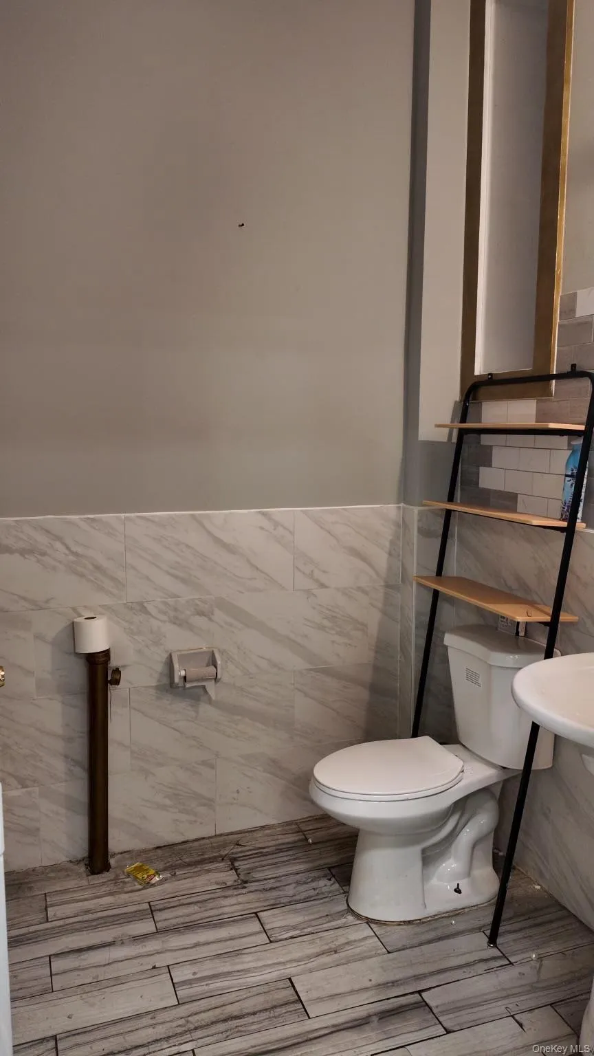 Half bathroom with tile walls and wainscoting Half bathroom with tile walls and wainscoting